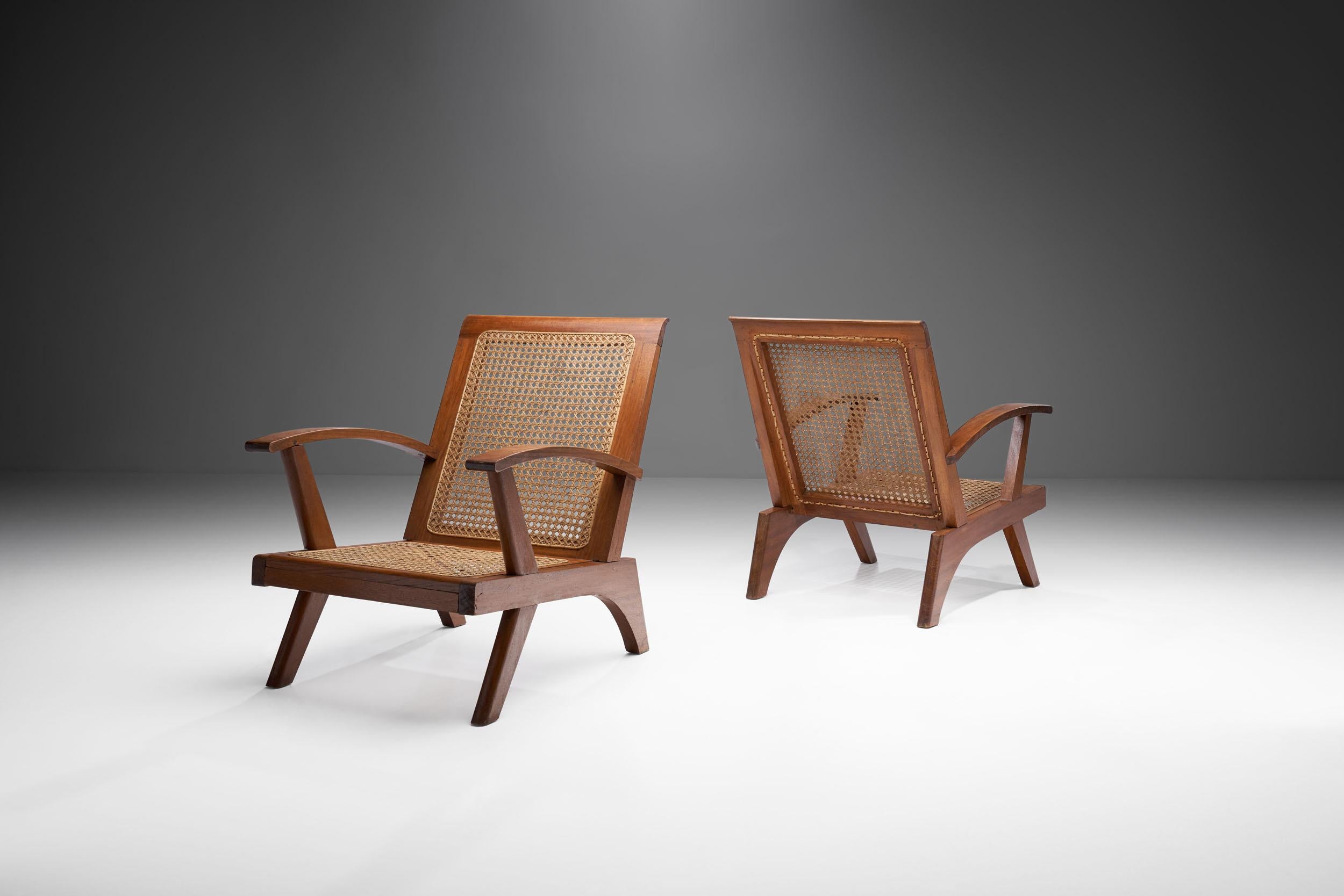 Dieses Paar französischer Sessel aus der Mitte des Jahrhunderts verbindet eine optisch beeindruckende Struktur mit einer fachmännischen Caning-Technik und hochwertigen Materialien. 

Wie im Vereinigten Königreich und in weiten Teilen Europas kam es