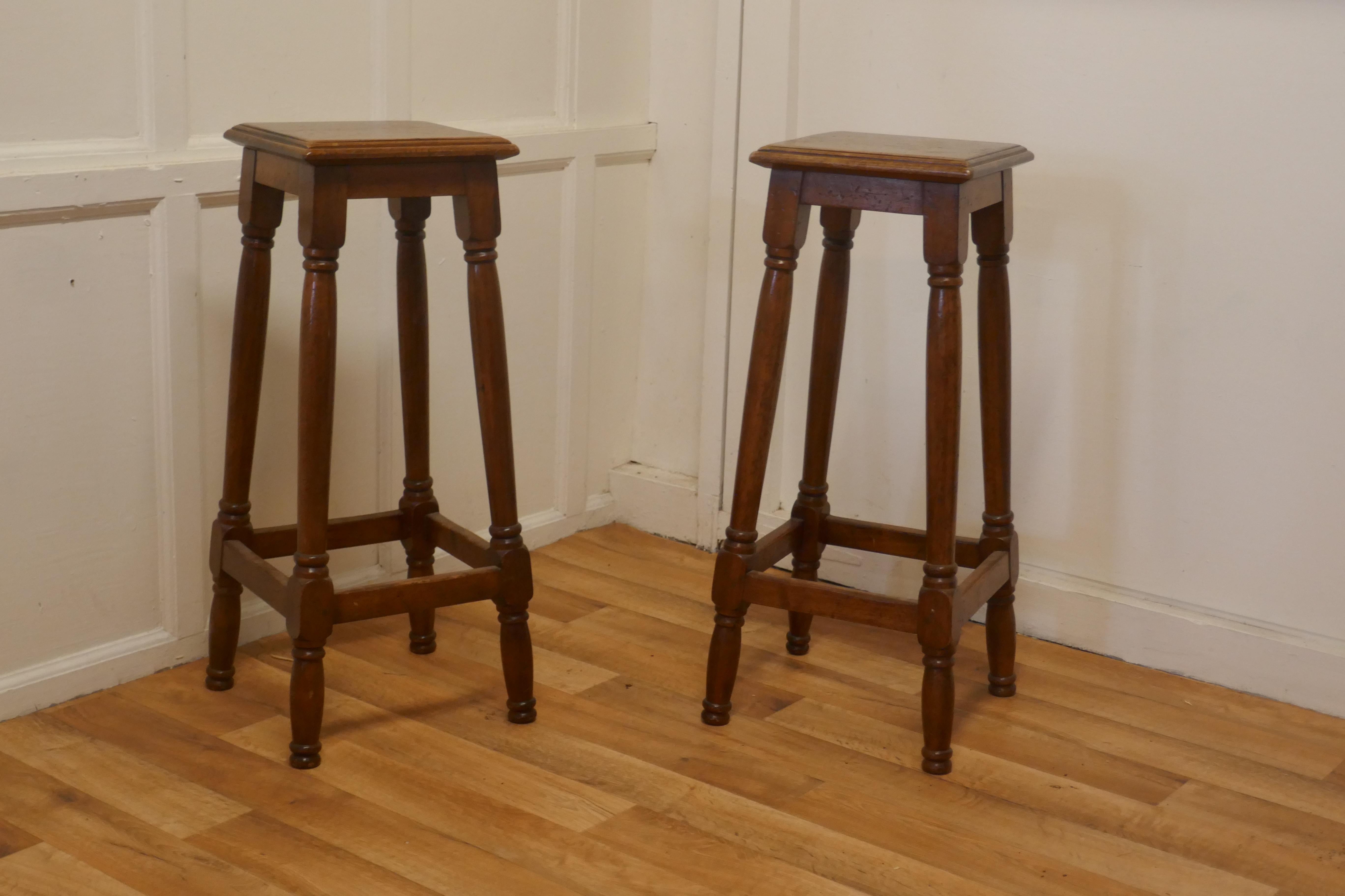 A Pair of French walnut farmhouse high kitchen stools

These are an elegant pair they have a square seat and are set on tall turned stretchered legs 
The stools are in good sound condition, and have an aged patina
 The stools are 32” high, the