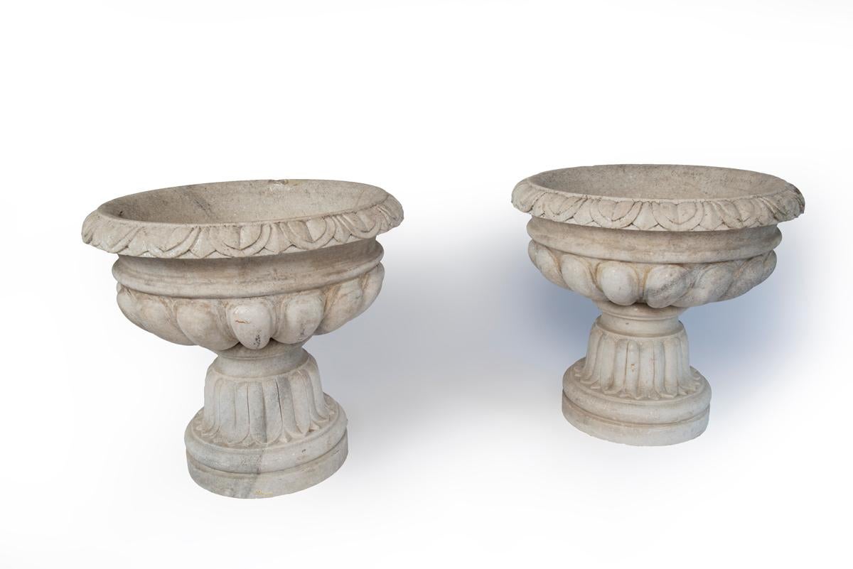 A pair of French white marble vases in four parts. The inside height of the vases or planters is 11 inches.