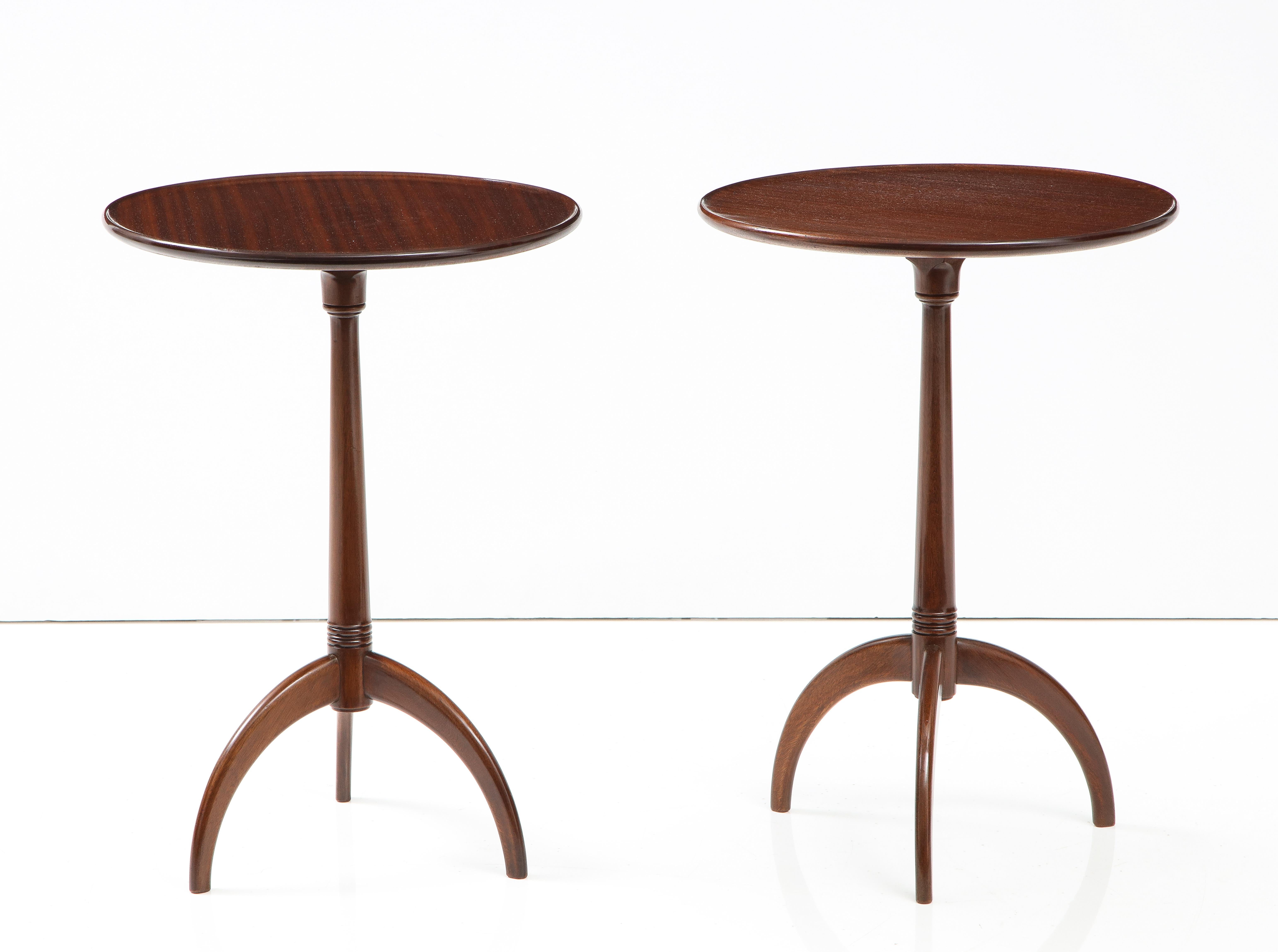 A pair of Danish mahogany side tables, Circa 1940s, by Frits Henningsen, each with a solid circular dished top raised on a turned spreading stem ending with three down curved legs. This is a true pair of tables, the tops are cut from the same tree