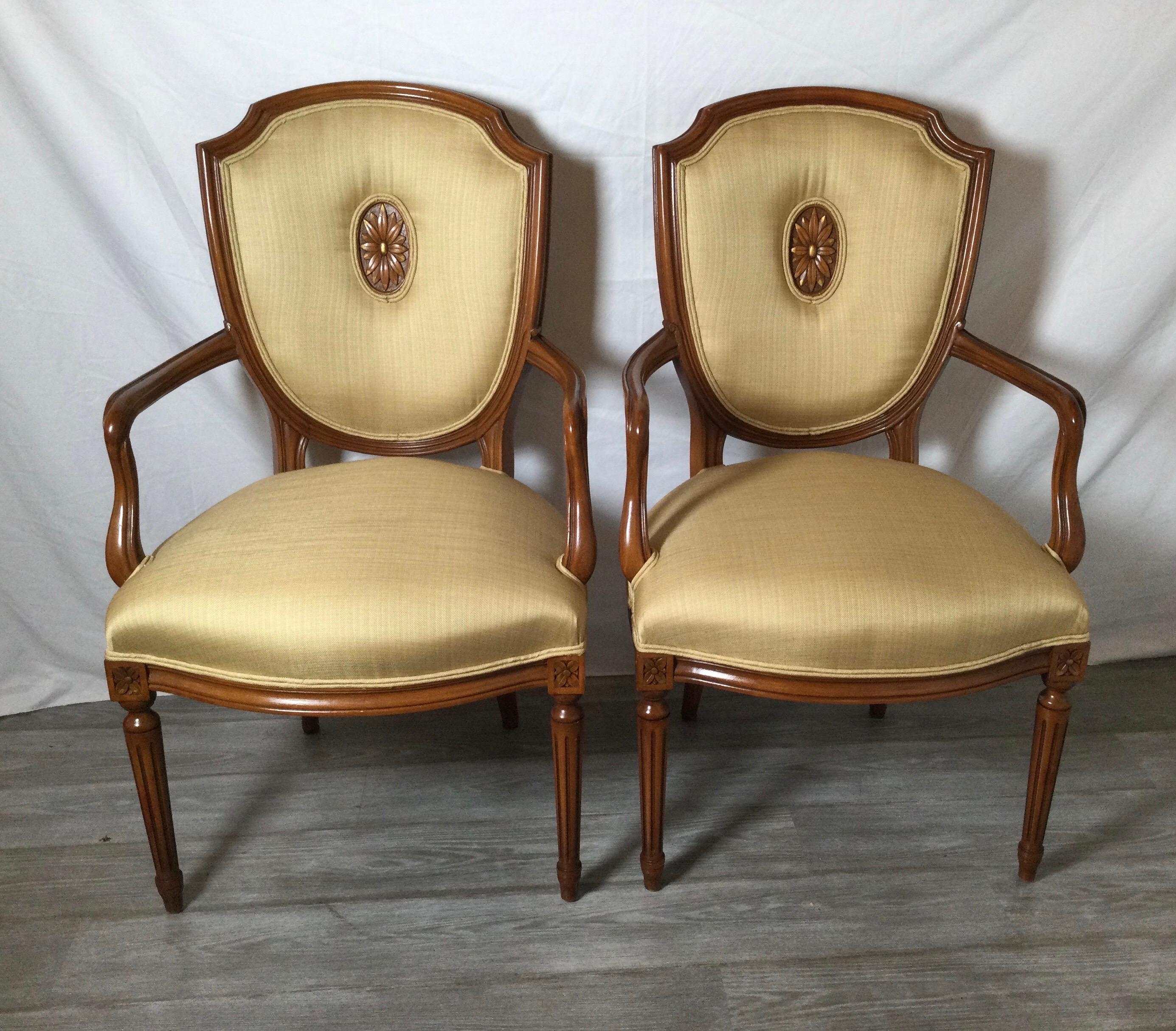 A pair of mid-20th century fruitwood shield back armchairs. The classically styled frames with hand carving in new light tan bronze woven linen fabric. The backs with a central caved wood inset.