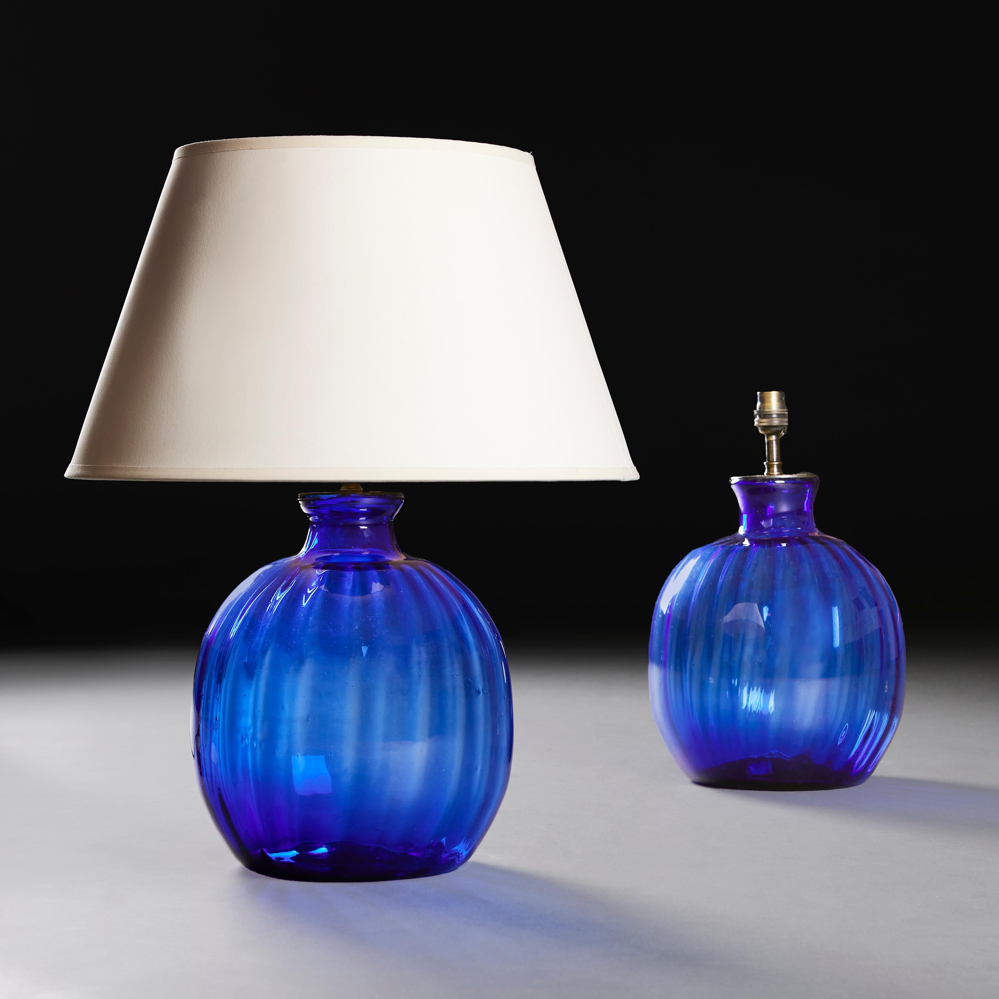 Ein Paar blaue Glaslampen aus der Mitte des zwanzigsten Jahrhunderts mit gadronierten Details und Flaschenhälsen. 
Frankreich, um 1950.
Höhe der Vase     28.00cm
Höhe mit Beschattung    53.00cm
Durchmesser der Basis    17.00cm

Bitte beachten Sie: