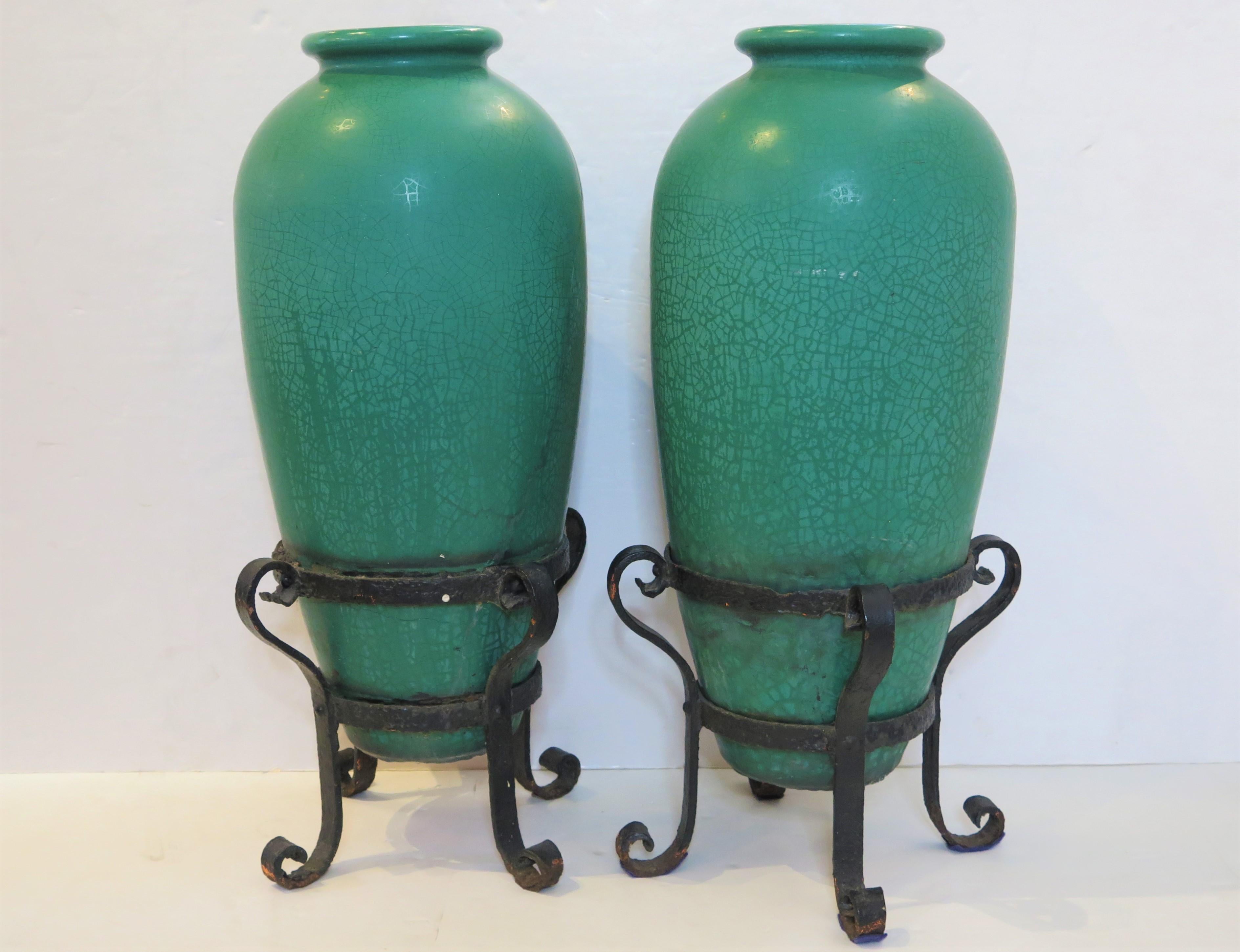 a gorgeous pair of tall, slender Arts and Crafts / Mission-style Galloway Pottery crackled glaze urns in blue-green / turquoise with handsome wrought iron bases / stands, each with hole for drainage, some repairs, United States, 19th