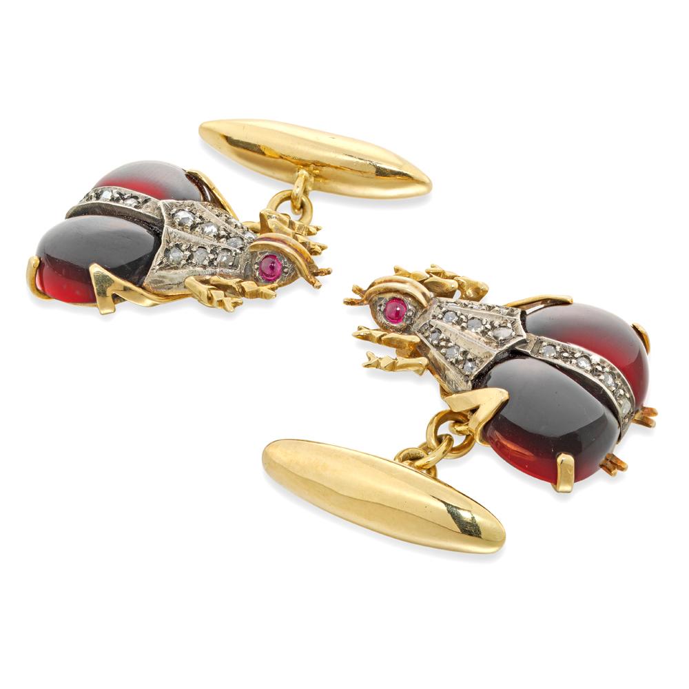 A pair of garnet and diamond beetle cufflinks made by Bentley & Skinner, each beetle set with two cabochon-cut segments and rose-cut diamonds to the body, with yellow gold head and legs and cabochon ruby-set eyes, with a torpedo shaped fastening