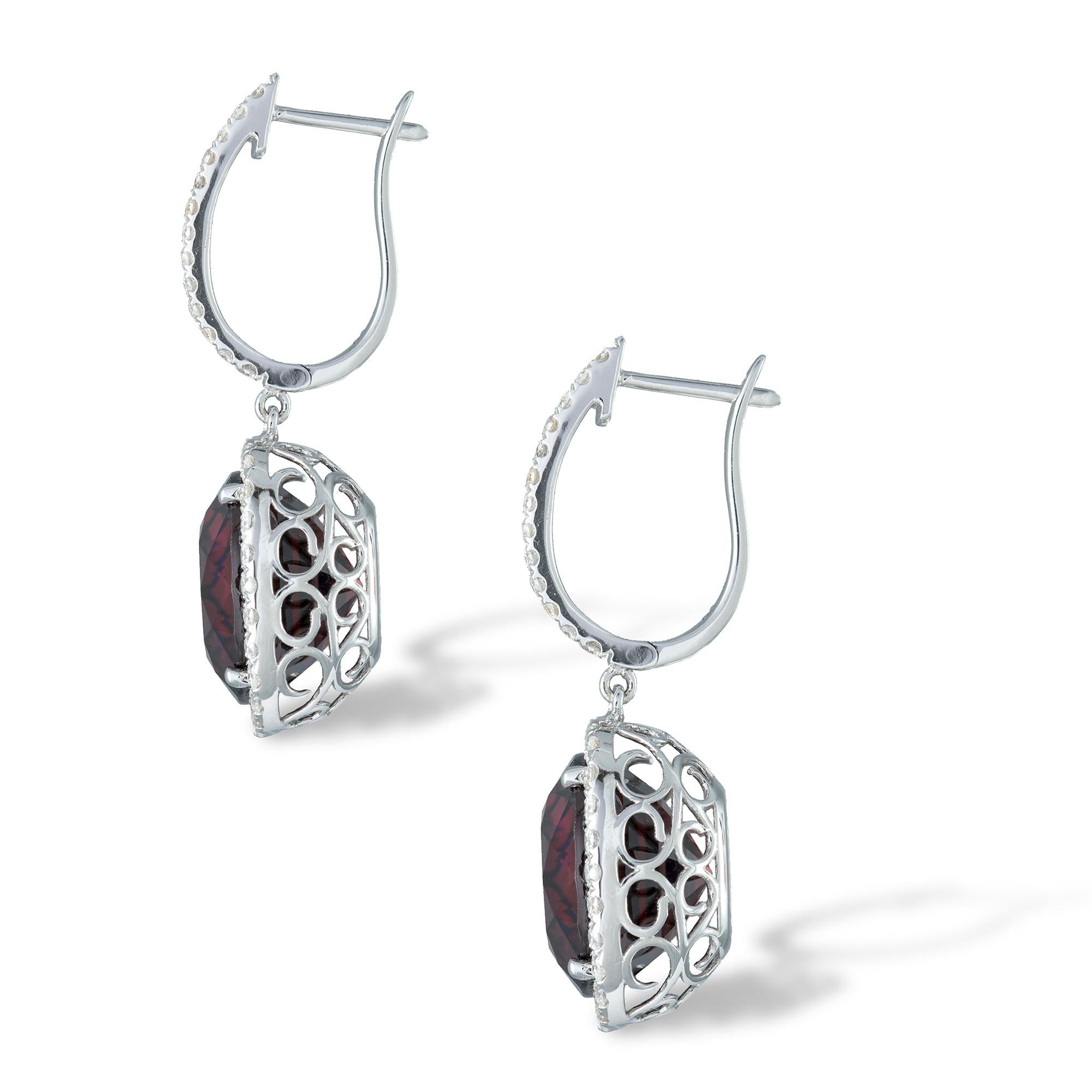 A pair of garnet and diamond cluster earrings, the cushion-cut garnets, weighing 22.42 carats, claw-set, each surrounded by twenty-seven brilliant-cut diamonds, suspended from a line of thirteen round brilliant-cut diamonds, total diamond weight