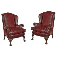 Vintage A pair of generous mahogany wing armchairs with shell carved knees