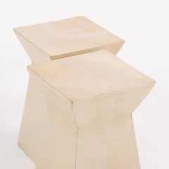 Un par de mesas de bebidas geométricas cubiertas de pergamino.