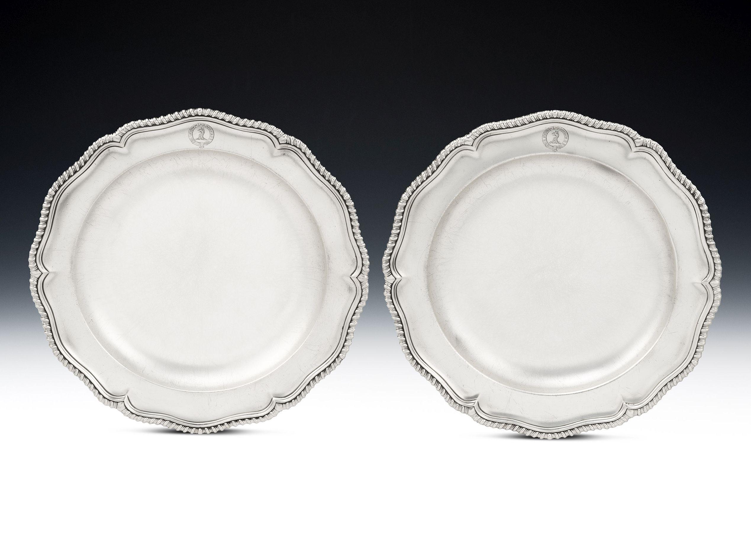 These very fine dishes are of a good large Size and are circular in form with a wide rim decorated with a shaped gadrooned band. Both have a deep bowl so that they could be used for serving a number of things on the dining table. The border is also