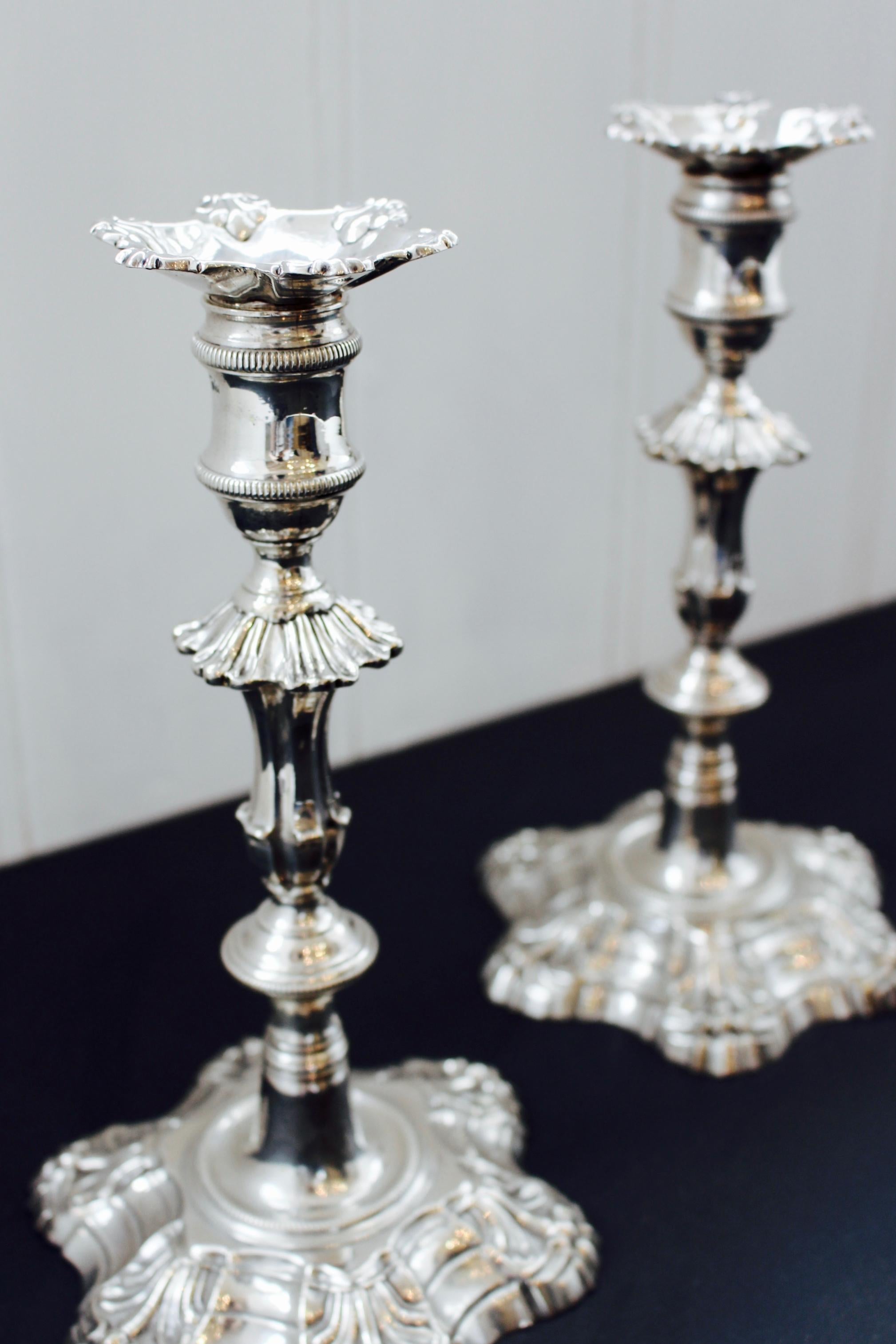 A pair of George II cast silver candlesticks by John Cafe, hallmarked London, 1752, the anthemion-decorated hexafoil sconces on reeded spool nozzles, spreading acanthus shoulders on segmented hexagonal baluster stems on acanthus-cast hexafoil bases,
