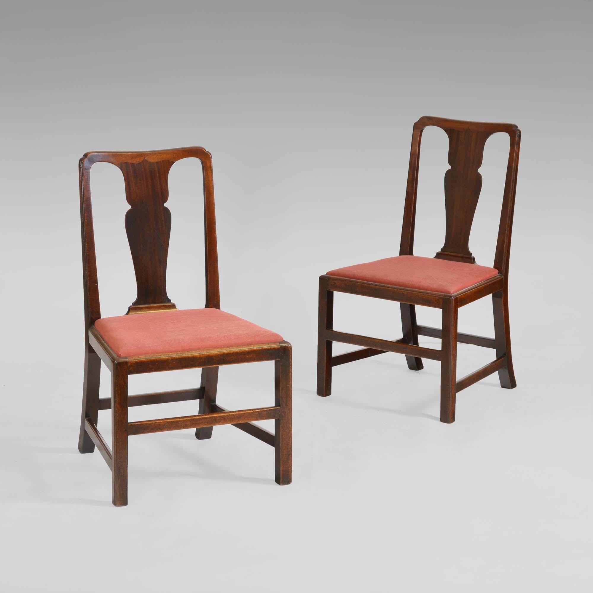 Coppia di sedie in noce di Giorgio II 
Coppia di sedie in noce di epoca georgiana, con schienale modellato e angoli rientranti con stecche a forma di urna impiallacciate, con cresta a punta, su sedili imbottiti a ribalta. Le gambe sagomate sono