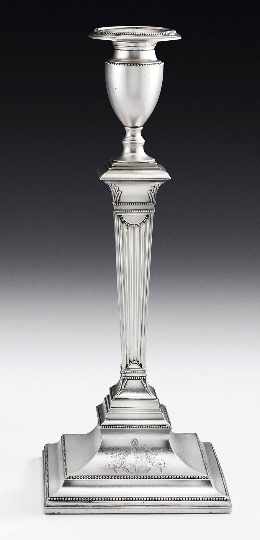 These George III sterling silver candlesticks were made in Sheffield in 1783 by Samuel Roberts & Company. Both stand on bevelled square bases decorated with fine beaded bands. The front of the base is engraved with a contemporary oval Armorial