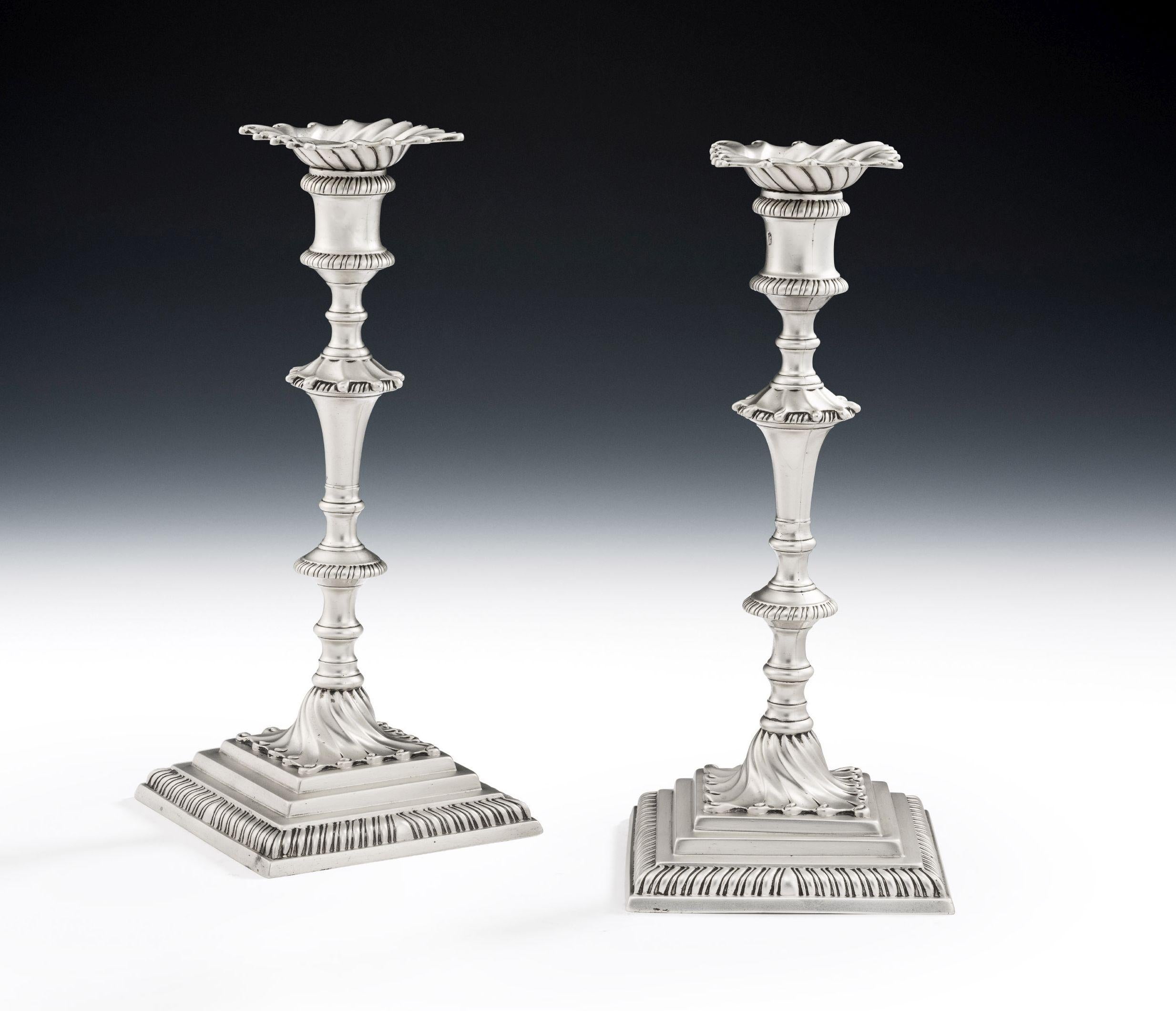 A very fine pair of early George III Cast Candlesticks made in London in 1771 by the specialist Candlestick maker, Ebenezer Coker.

The Candlesticks stand on a stepped square base which is decorated with gadrooning. The central shaped shaft is