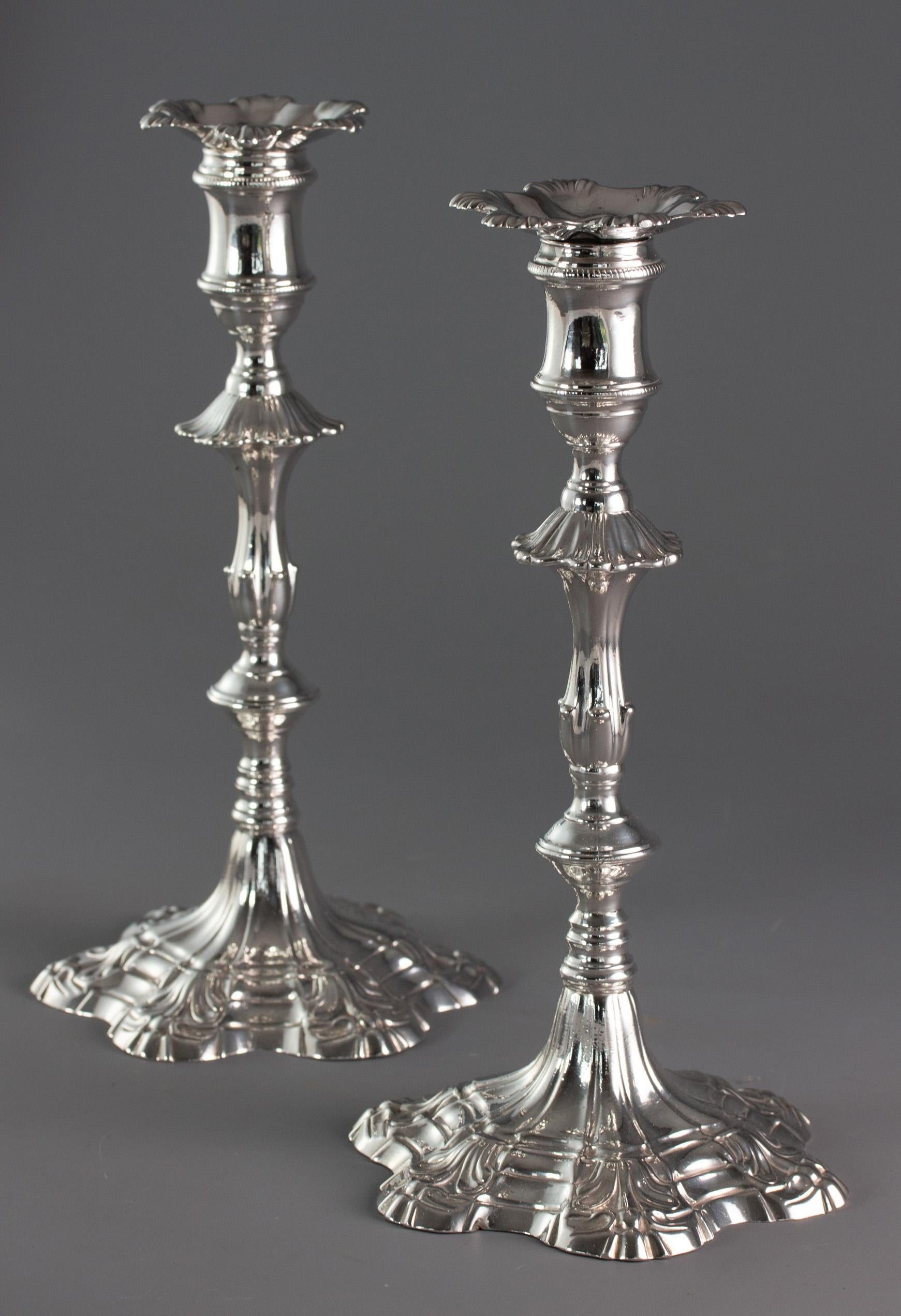 A pair of George III cast silver candlesticks, each with shaped hex foil, stepped and fluted bases rising to a knopped and fluted stem topped with a cotton-reel capitals and matched sconces.

Both candlesticks are clearly hallmarked for the