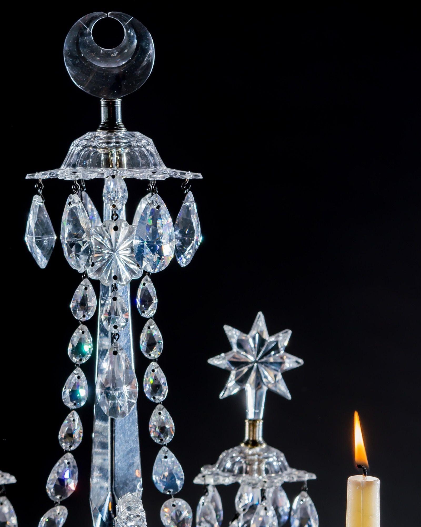Les bases concaves carrées en forme d'urne, montées avec des récipients en forme de diamant émettant quatre bras taillés en encoche, deux en forme de volute supportant des bacs de récupération et des réserves de bougies, deux autres montés avec des
