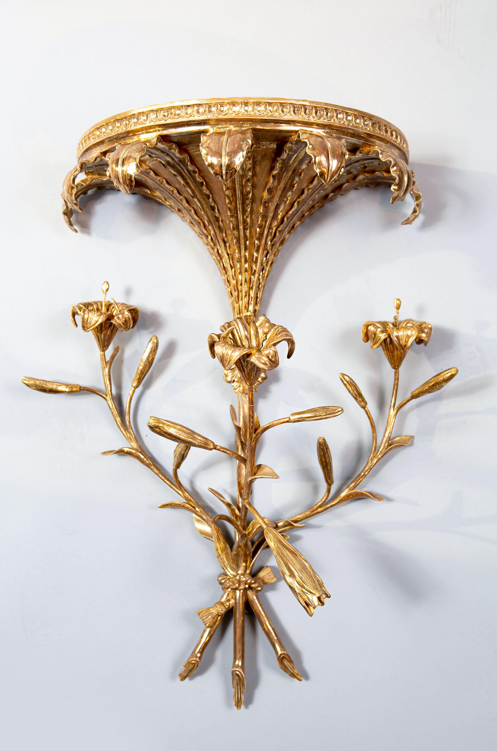A magnificent pair of late 18th century George III giltwood wall brackets fashioned as bunches of lilies suspended below festoons of 7 leaves with rippled edges and neoclassical moulded tops.

England, circa 1780

Measures: Height 24.5 ins /