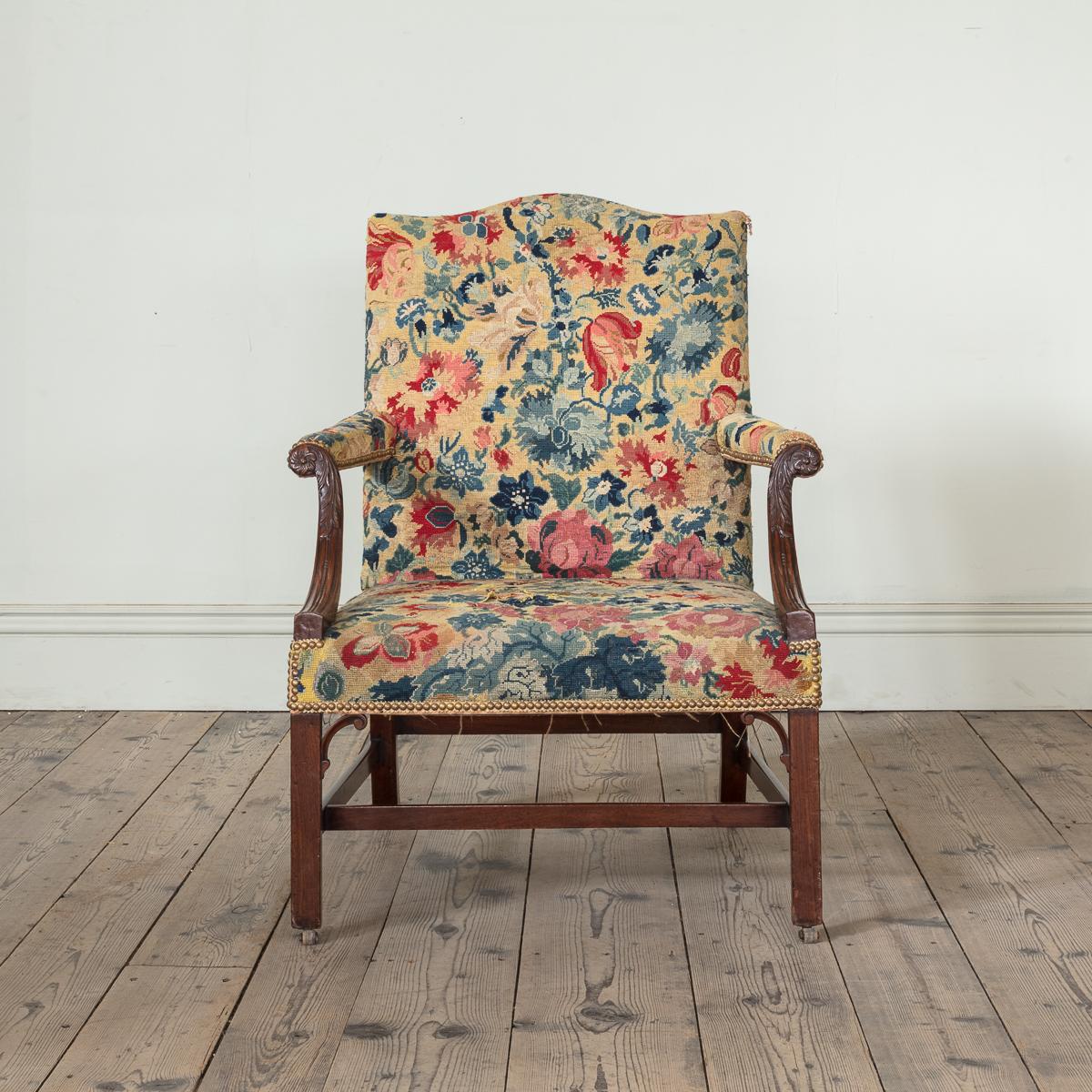 A Pair of George III Mahogany Gainsborough Chairs, with Needlepoint Upholstery

With shaped camelback seat, with carved flower, acanthus and bead and reel scrolling arms, on plain square legs with c scrolling spandrels, on brass and leather casters.