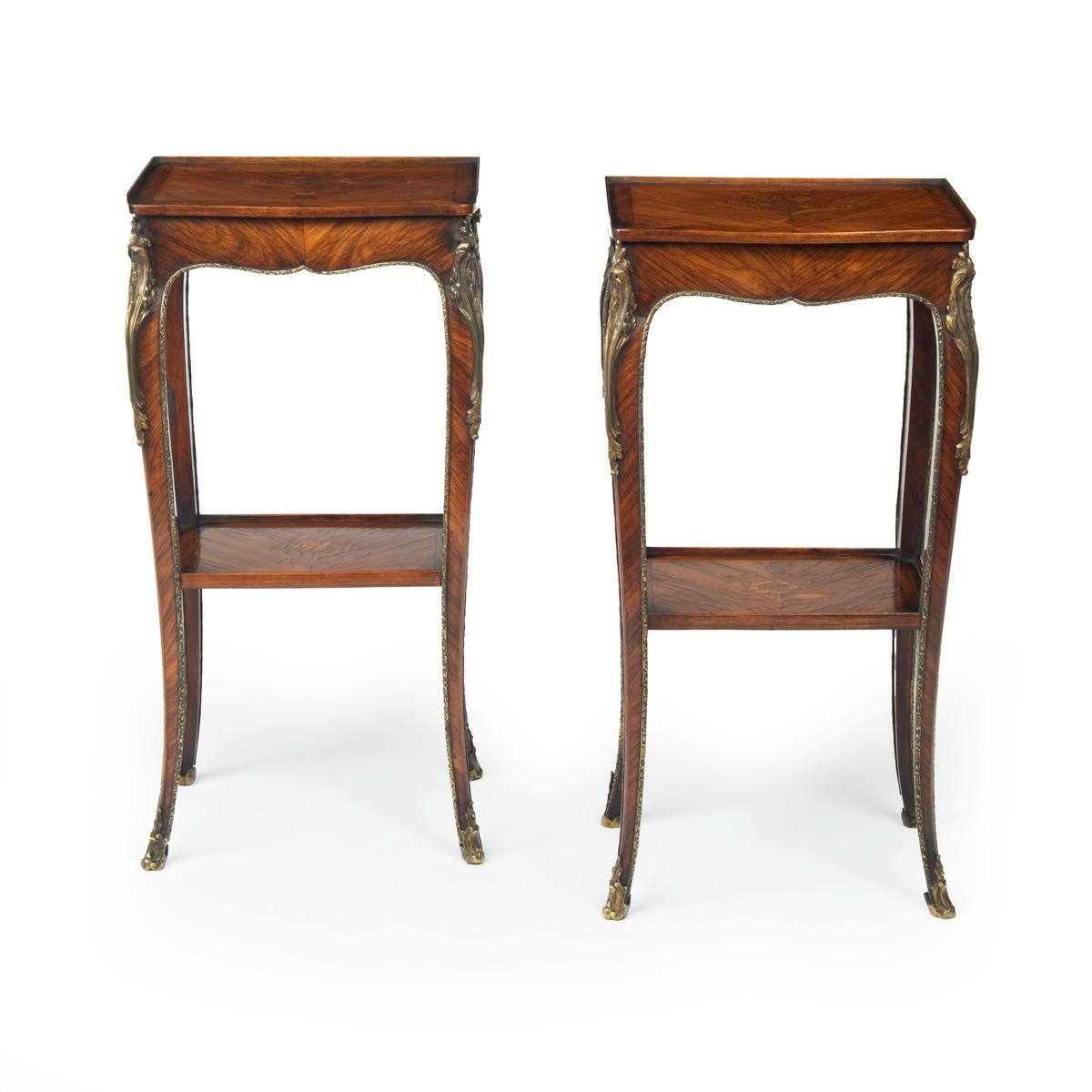 A pair of George III marquetry tables in the French taste, each of rectangular form, the top and under tier with a floral spray on a diagonal kingwood quarter veneered ground within kingwood cross banding, with a single frieze drawer at one end, the