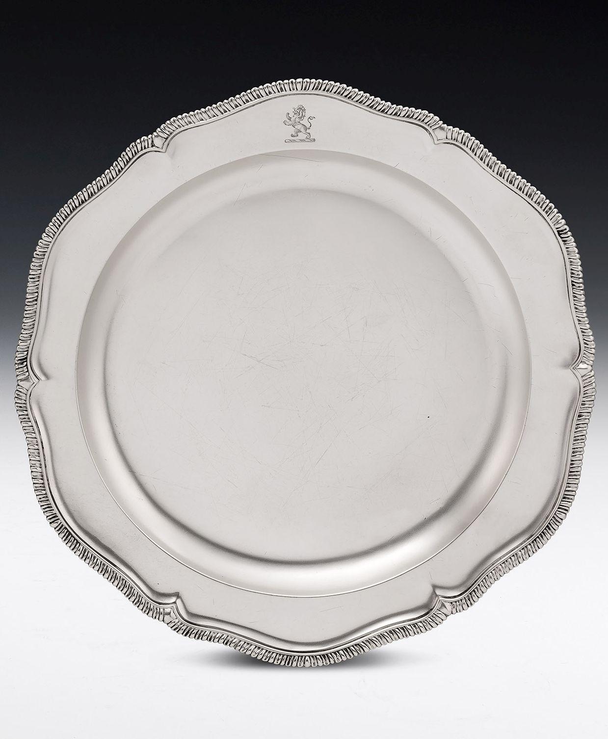 This rare pair of early George III sideboard dishes come from the workshops of the Royal silversmith, Thomas Heming, and were made in London in 1763. The Dishes are circular in form with a shaped rim decorated with gadrooning. The bowl rises up to a