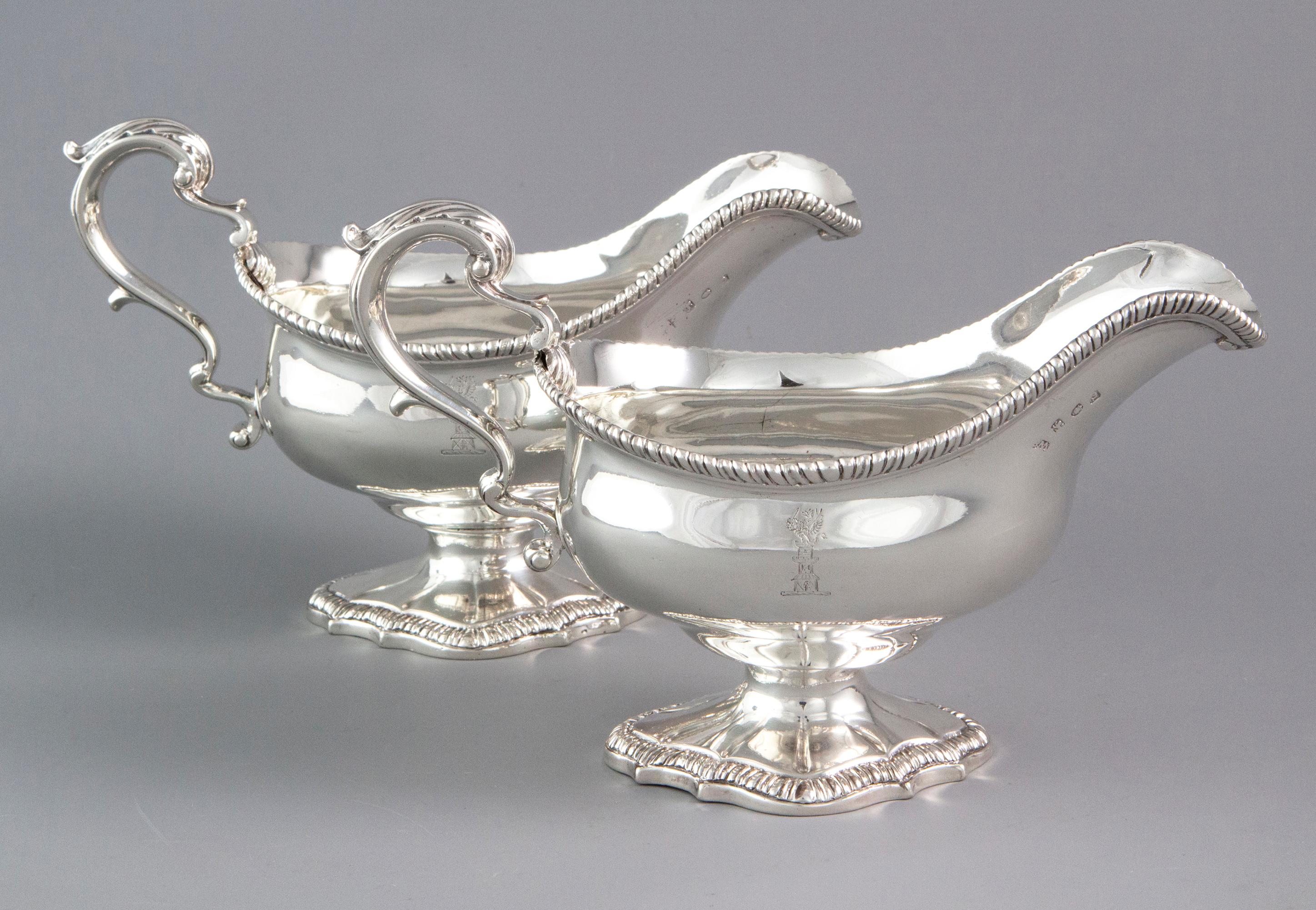A very good pair of large size late 18th century silver sauce boats of typical form. With leaf capped scroll handles and gadrooned rims. Standing on a shaped pedestal foot with gadrooned edge. Both pieces are crested to one side with a dragon