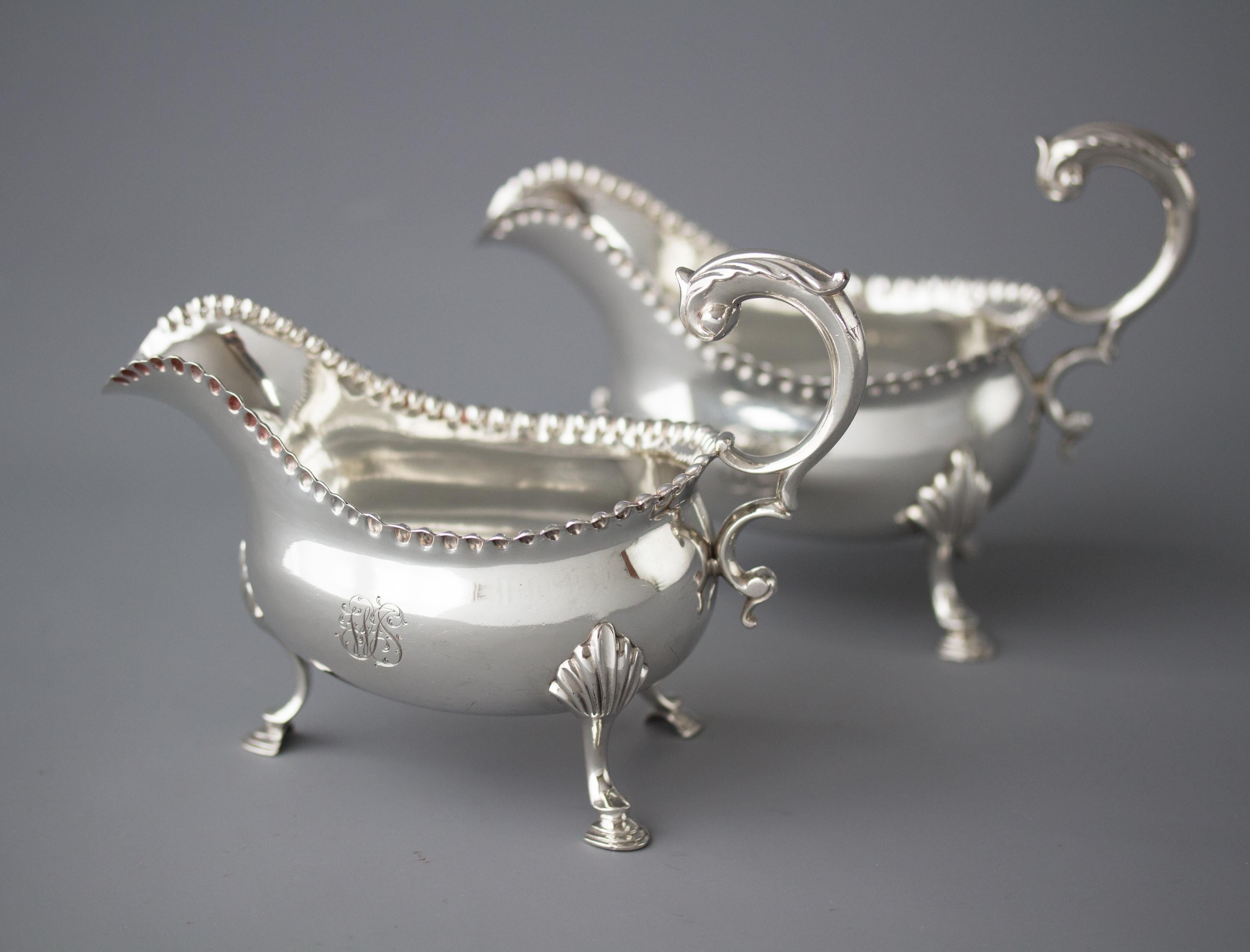 A very fine pair of George III silver sauce boats by William & James Priest. Of plain oval form, with raised bead decoration to the rim. A flying C-scrolled handle mounted with and acanthus leaf. Standing on three shell and hoof legs. Engraved with