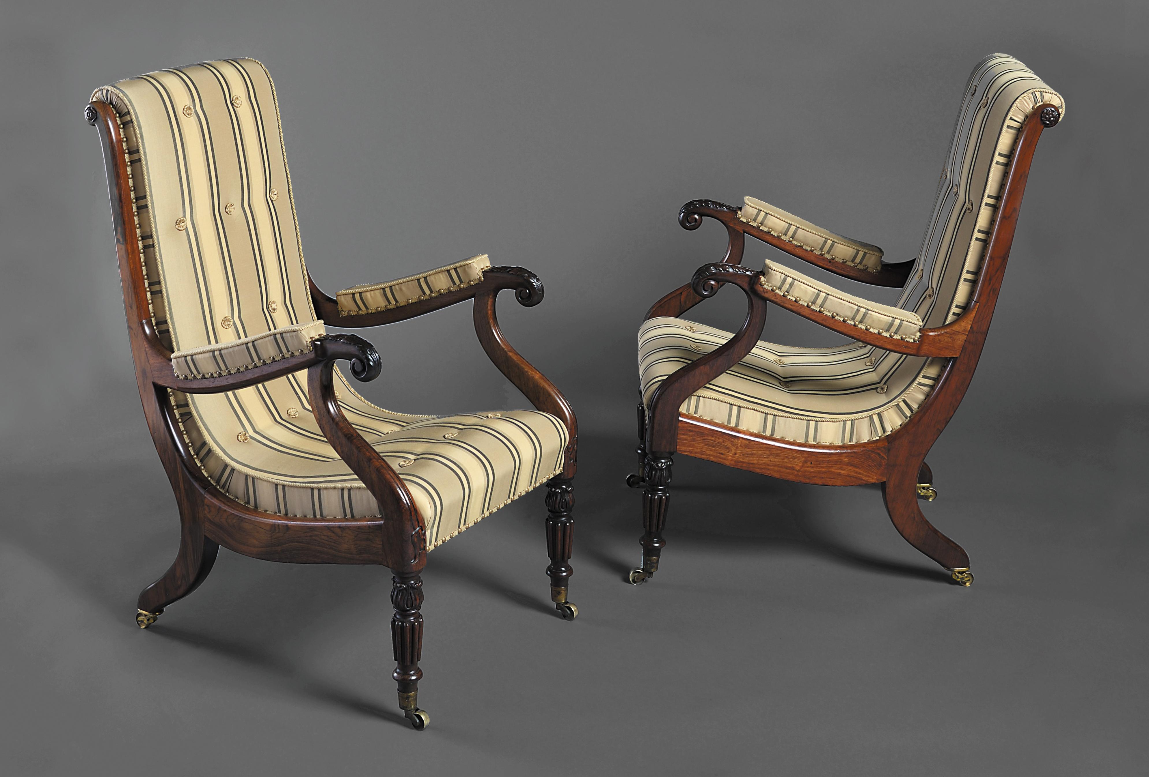 A fine pair of George IV Irish library armchairs, the well shaped backs with scroll shaped profile, acanthus carved arms, resting on turned fluted legs, with lotus leaf carving and brass cup castors.

Attributed to Williams & Gibton 
