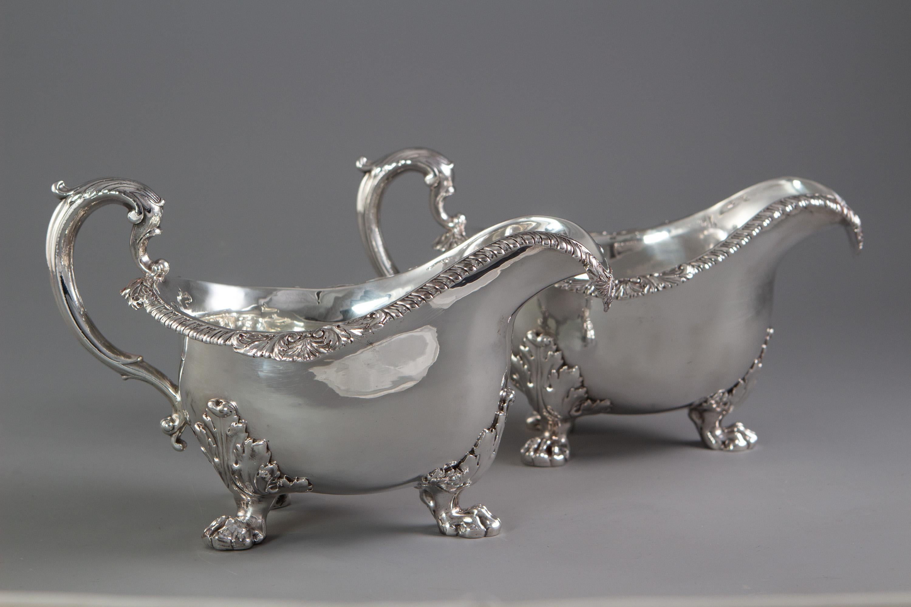 This rare pair of silver sauce boats are of large bellied oval form with a gadrooned rim sweeping round the down swept pouring lip. C-scroll handle topped with cast acanthus leaf decoration. Standing on three cast, acanthus topped, lion’s paw