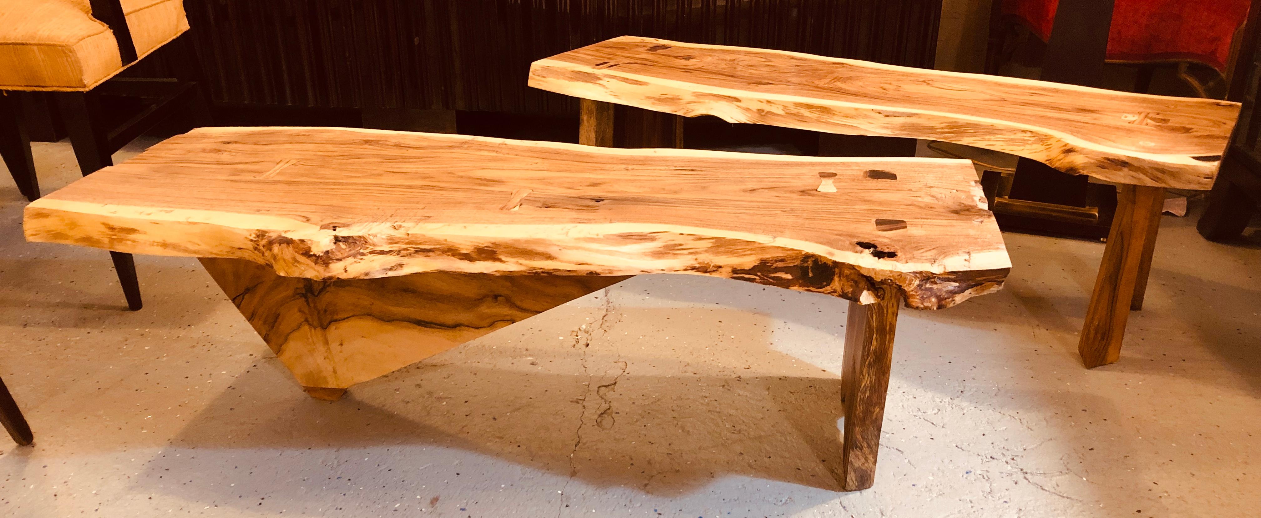 A pair of George Nakashima style tree bark slab benches or tables. This compatible pair of slab benches or coffee tables are done in the manner of George Nakashima with fine attention paid to tenon and mortise detail and craftsmanship. The solid