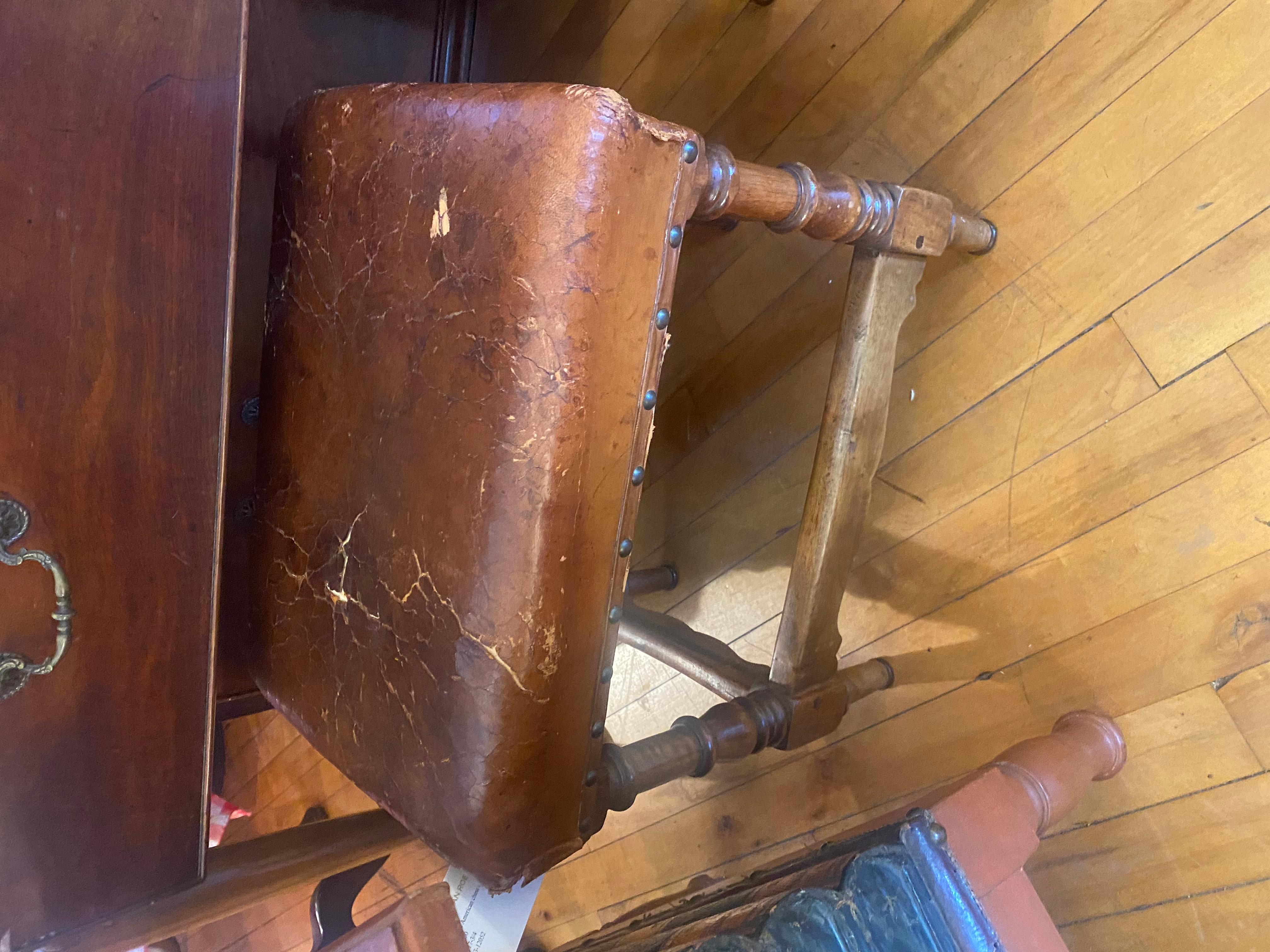 A pair of George V leather upholstered fireside stools with nail head trim. Distressed leather is original. Lovely old patina, great color.  Priced per stool. Would look great in library, office or living room.  Handsome.