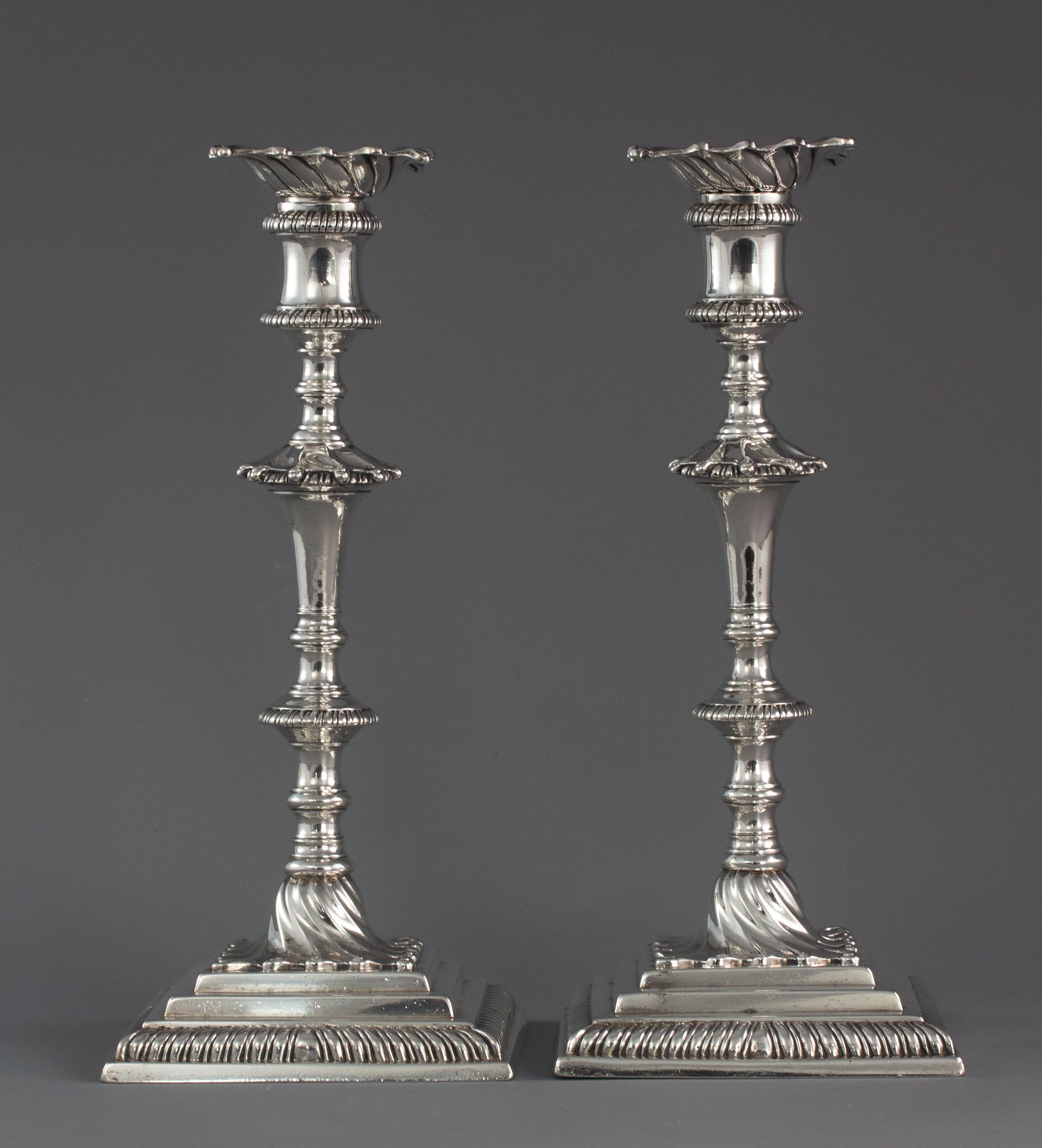 A superb pair of cast silver George III silver table candlesticks with square step bases, spiral stem with gadrooned knops and conforming sconces.

Marked for London 1766/7 by Ebenezer Coker. Also marked to the capitals and sconces.

 Both