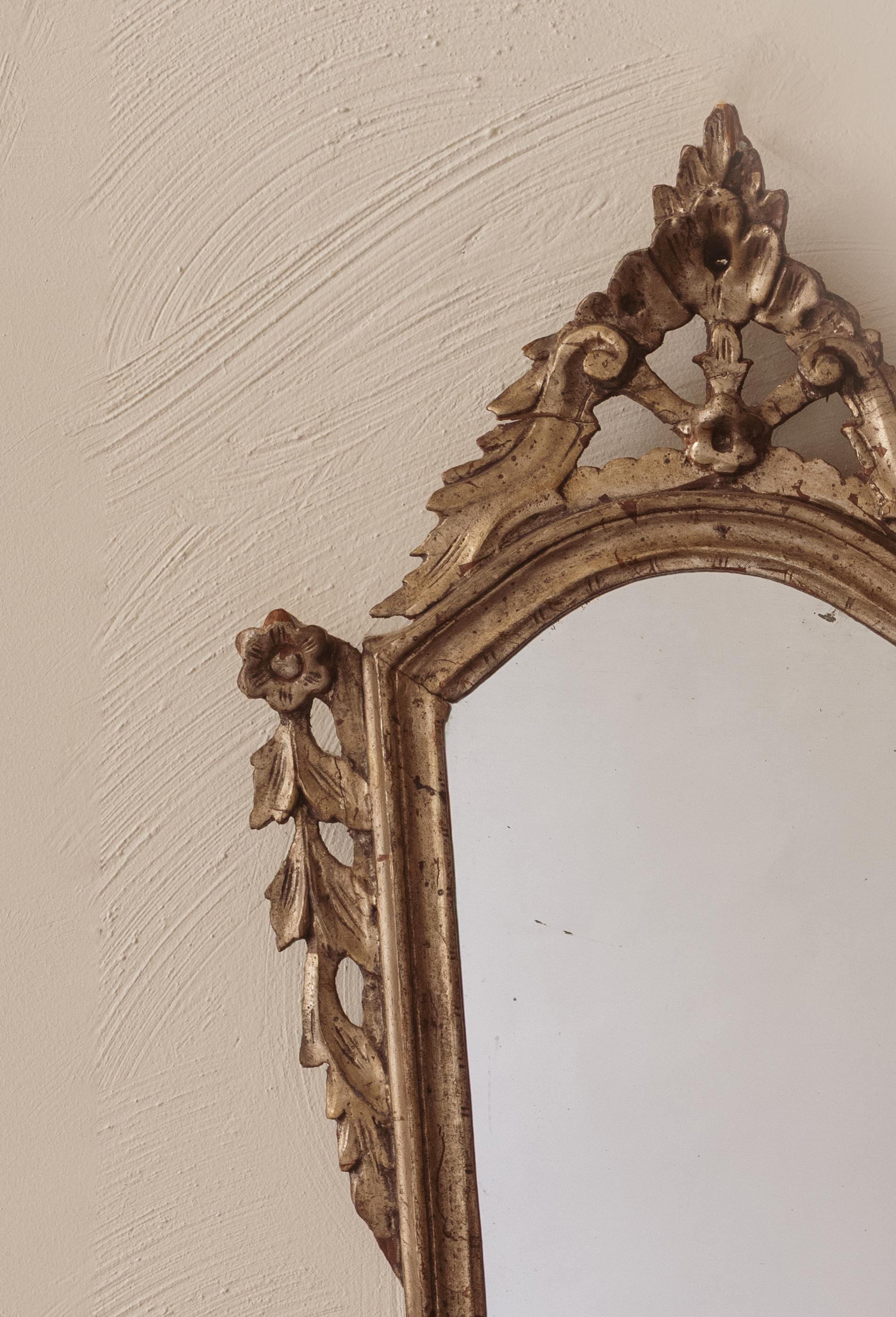 A pair of silvered carved wood mirrors with triangular crests. 

Italy, circa 1880