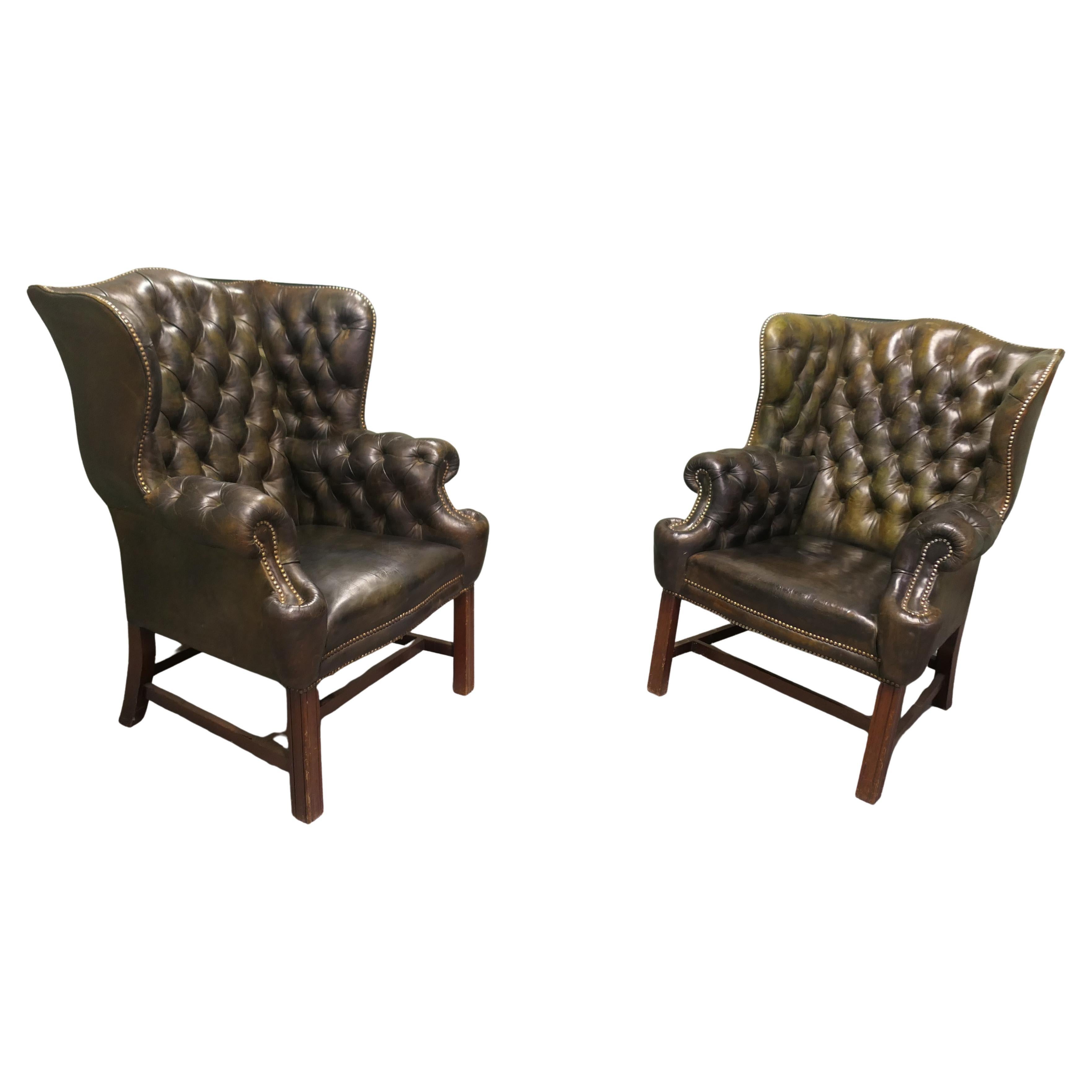 Una coppia di sedie Chesterfield in pelle con schienale ad ala da gentiluomo in stile georgiano