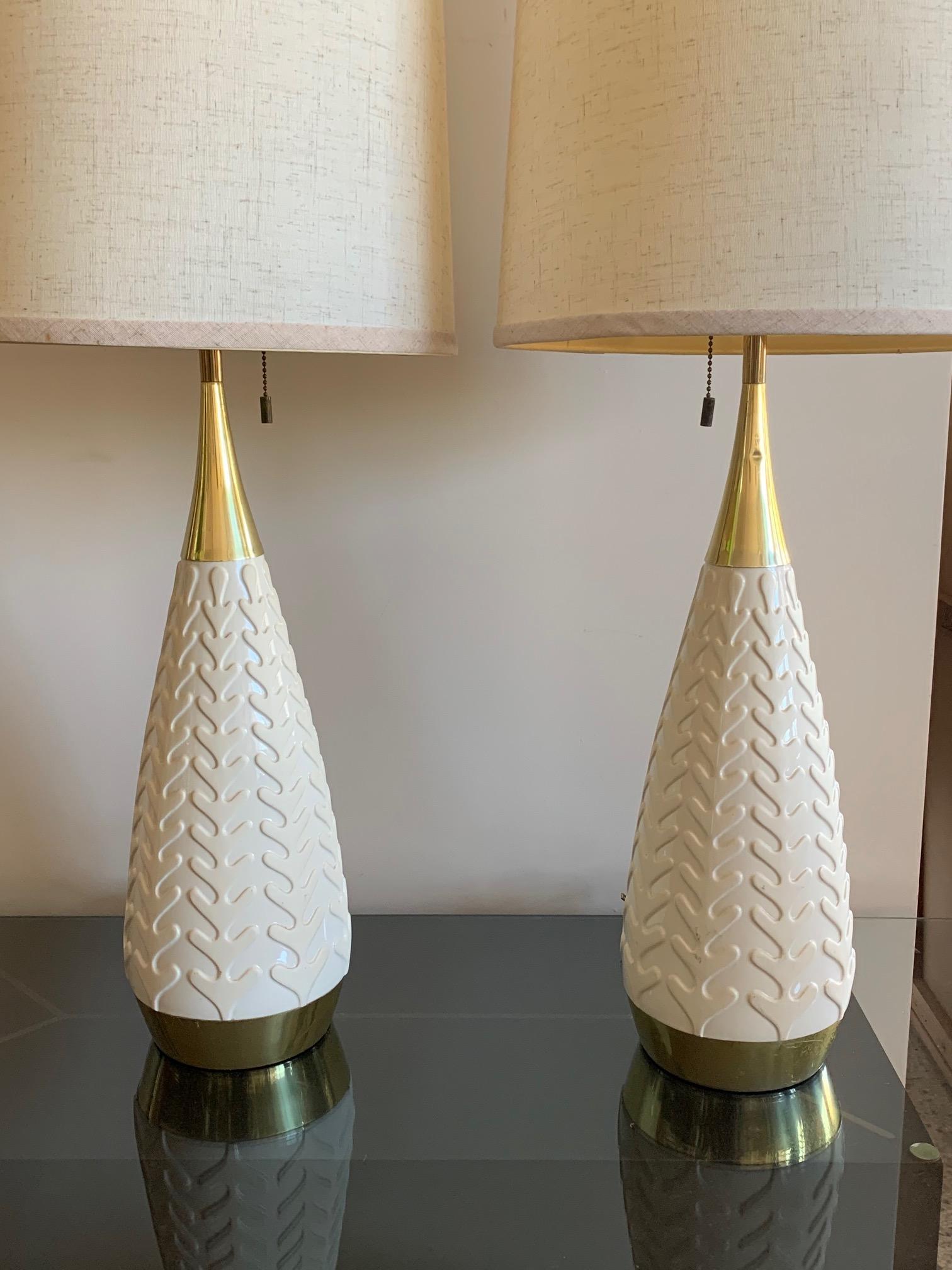 A pair of unusual Gerald Thurston/Lightolier table lamps. Ceramic with decorative pattern, three way bulb switch, polished brass.