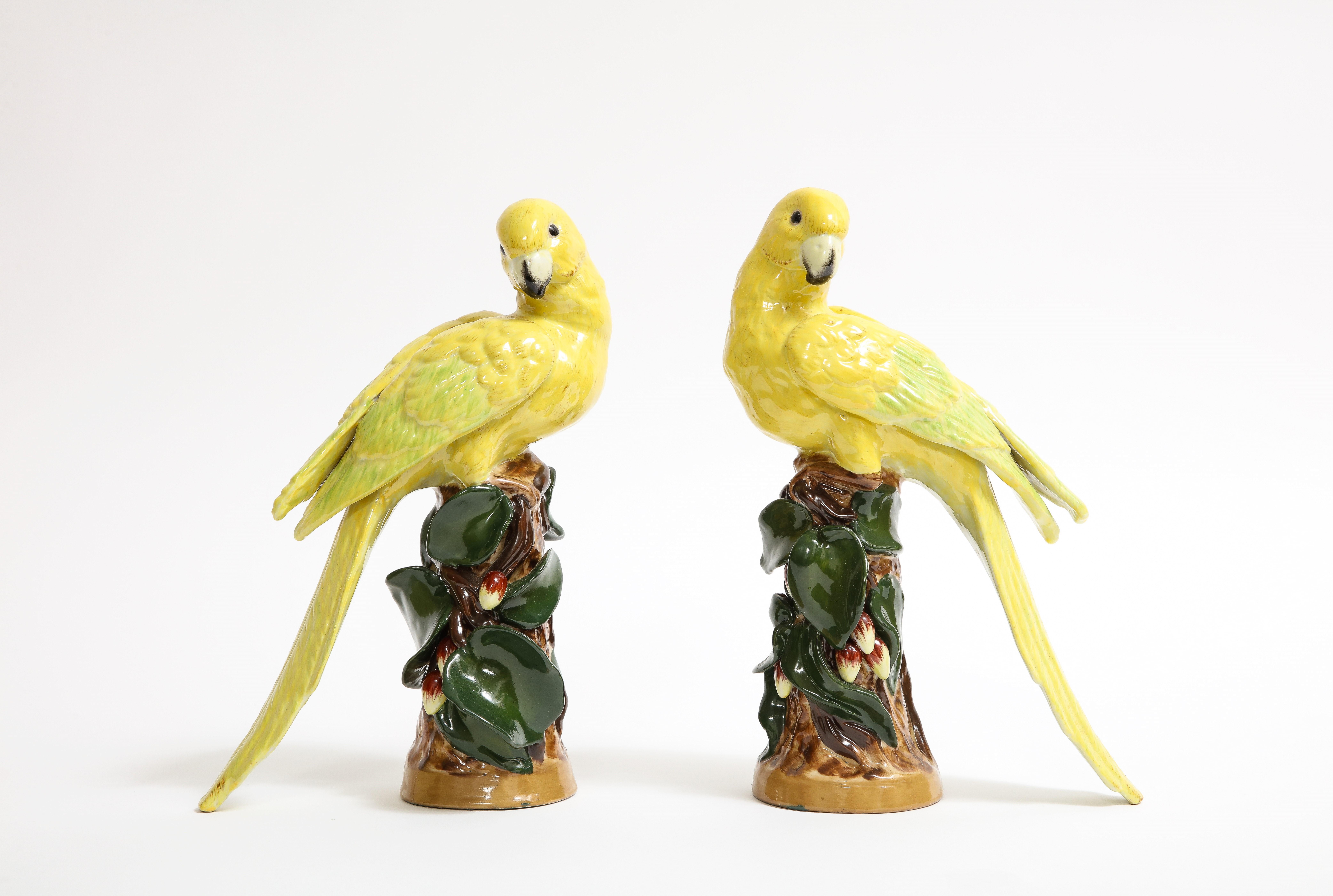 A Marvelous Pair of German Porcelain Birds in the Louis XVI Style. Each bird is hand-carved and hand-painted and can be seen perched on a tree branch with green foliage. The birds are marvelous with tremendous detail in their feathers and wings. The