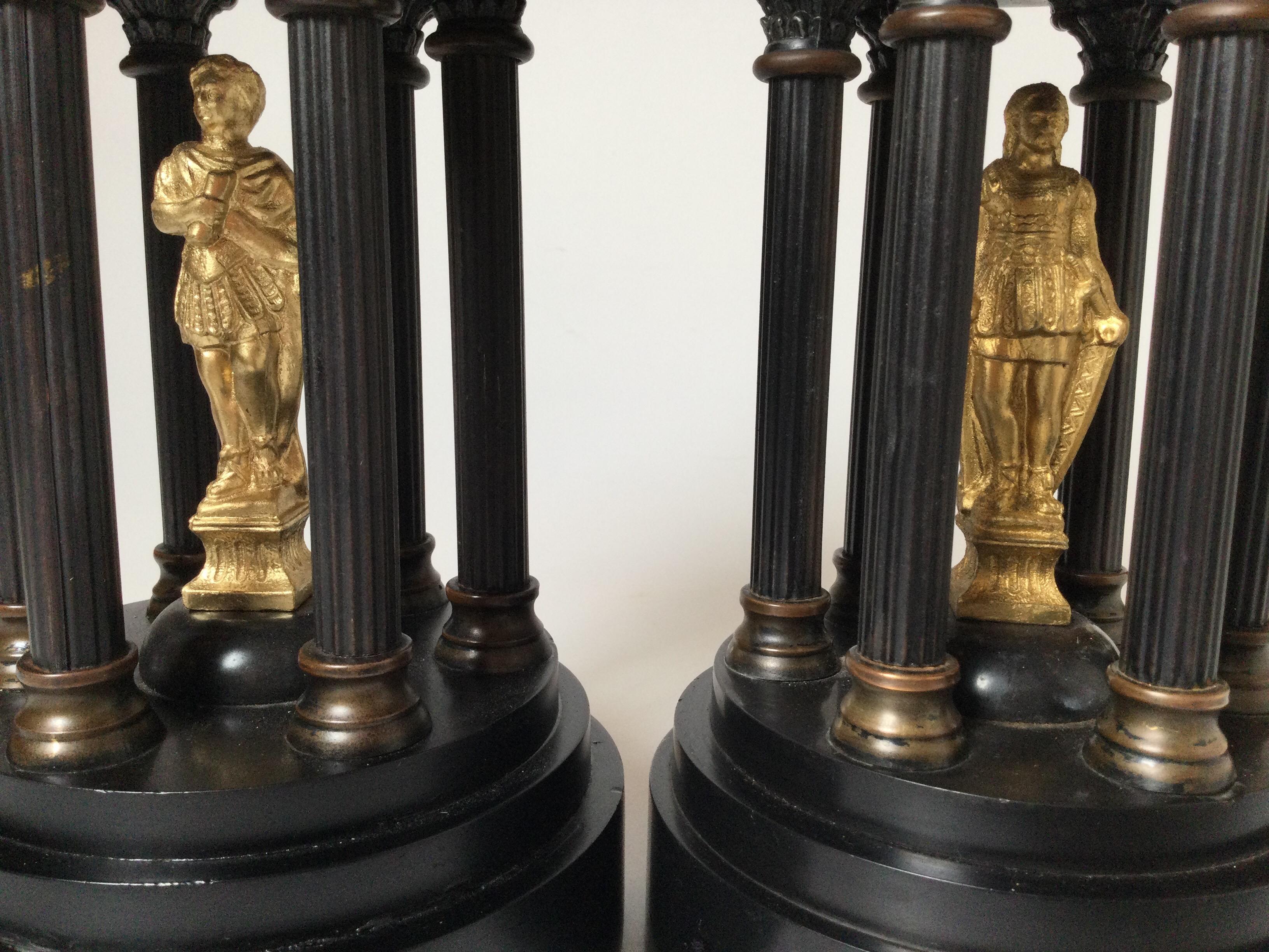 The round Neoclassical garnitures with columns surrounding a gilt bronze center figure. The rounded top with high finial. some slight chipping on the edge of one.