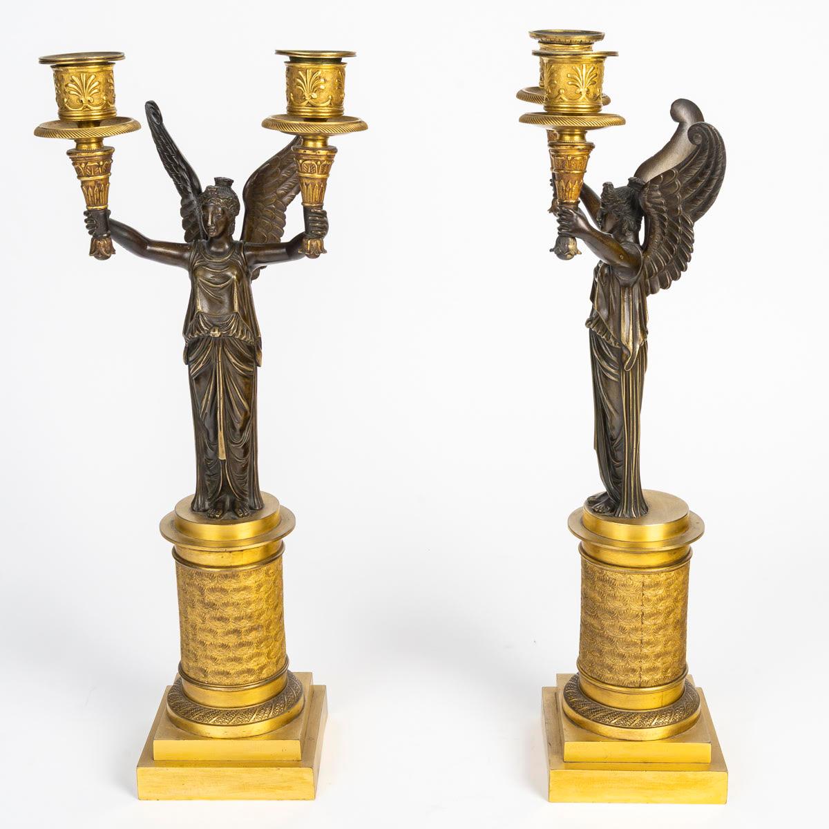 Français Paire de candélabres en bronze doré et patiné représentant des victoires ailés. en vente