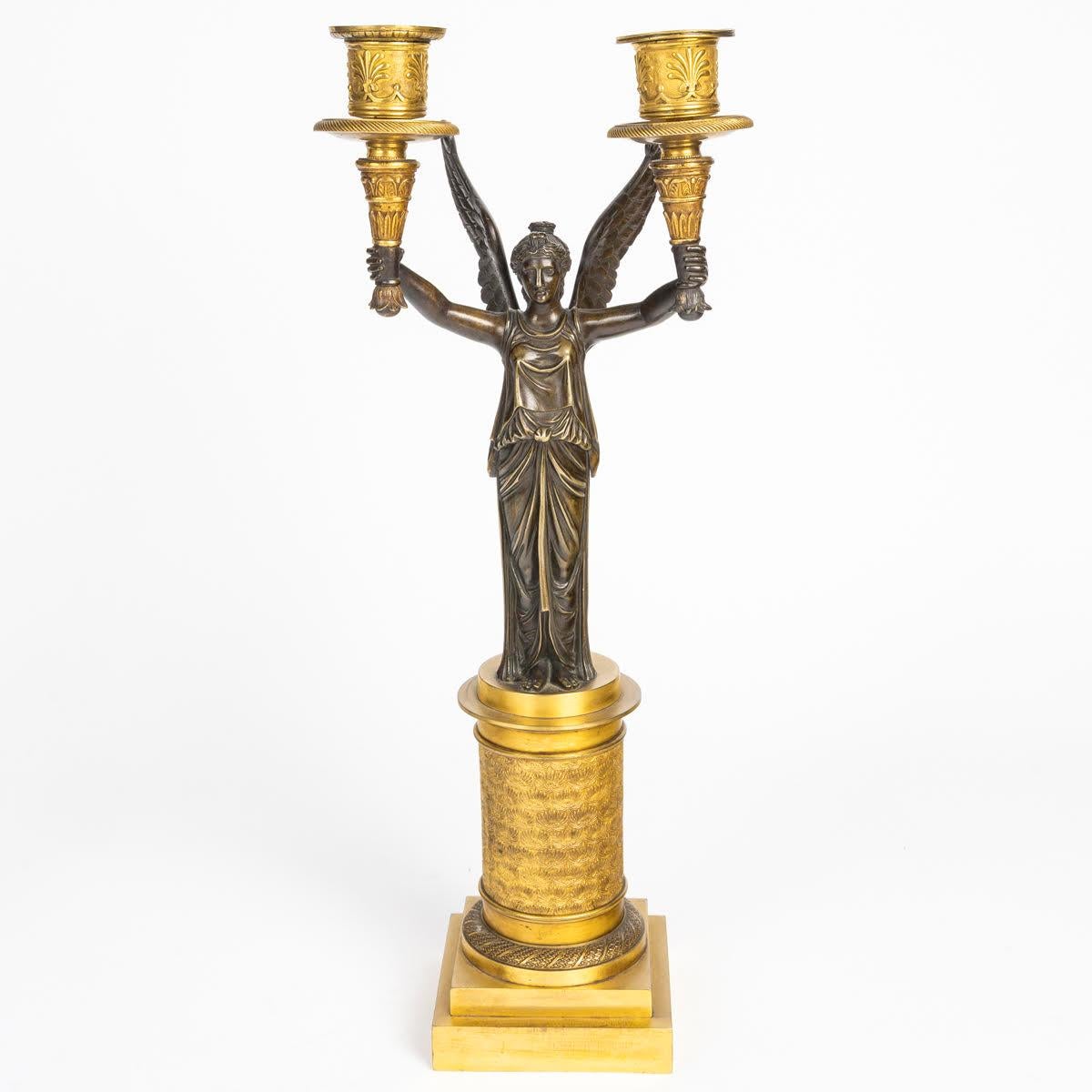 Doré Paire de candélabres en bronze doré et patiné représentant des victoires ailés. en vente