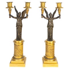 A Pair of Gilt Bronze and Patinated Candelabra with Winged Victories.