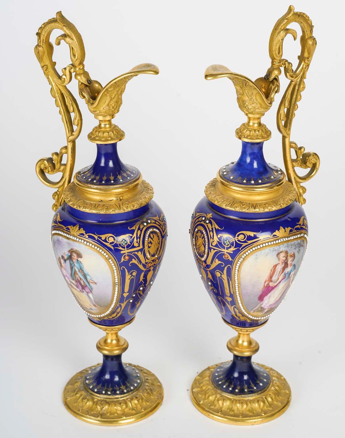 A pair of gilt bronze and royal blue porcelain ewers, 19th century, Napoleon III period.

A pair of gilt bronze and royal blue porcelain ewers, gold enamelled with a hand-painted galant scene on the front and floral decoration on the back, fine