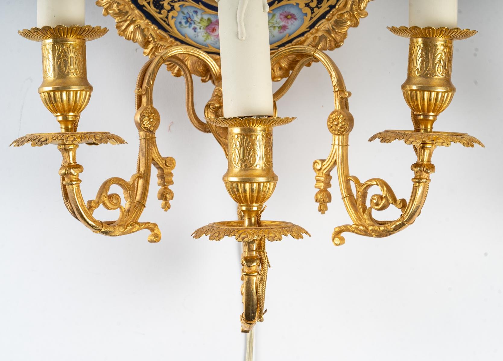 A pair of gilt bronze and Sèvres porcelain sconces, Napoleon III period, 19th century.
Measures: H: 49 cm, W: 28 cm, D: 14 cm.