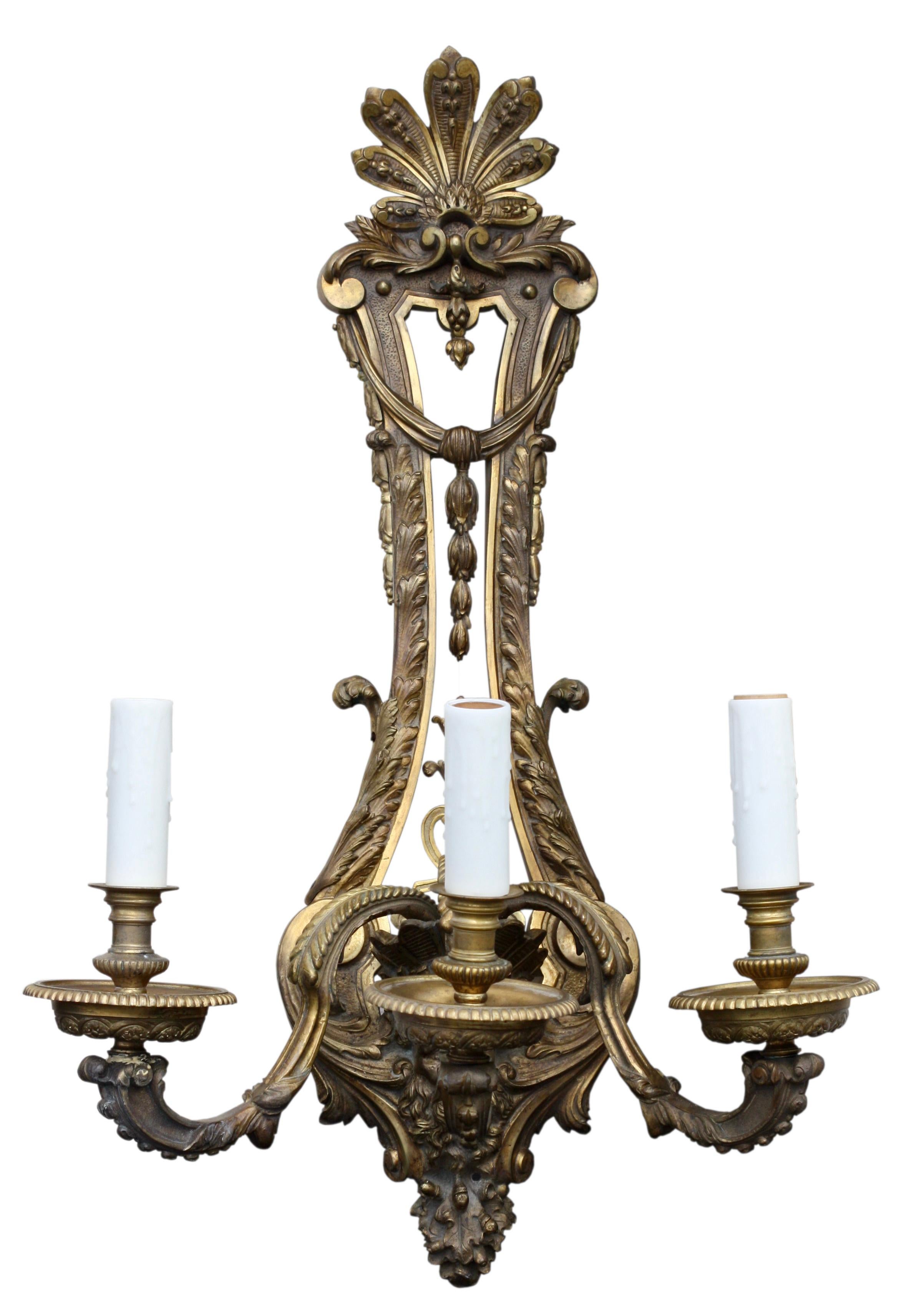 A pair of gilt-bronze sconces, Louis XVI style, circa 1880
The two light console-shaped branches with foliage issued from a fluted cornocupia with acanthus leaves and pearls
Measures: Height 24 in. (60.96 cm.), 
Width 21 in. (53.34 cm.).
 