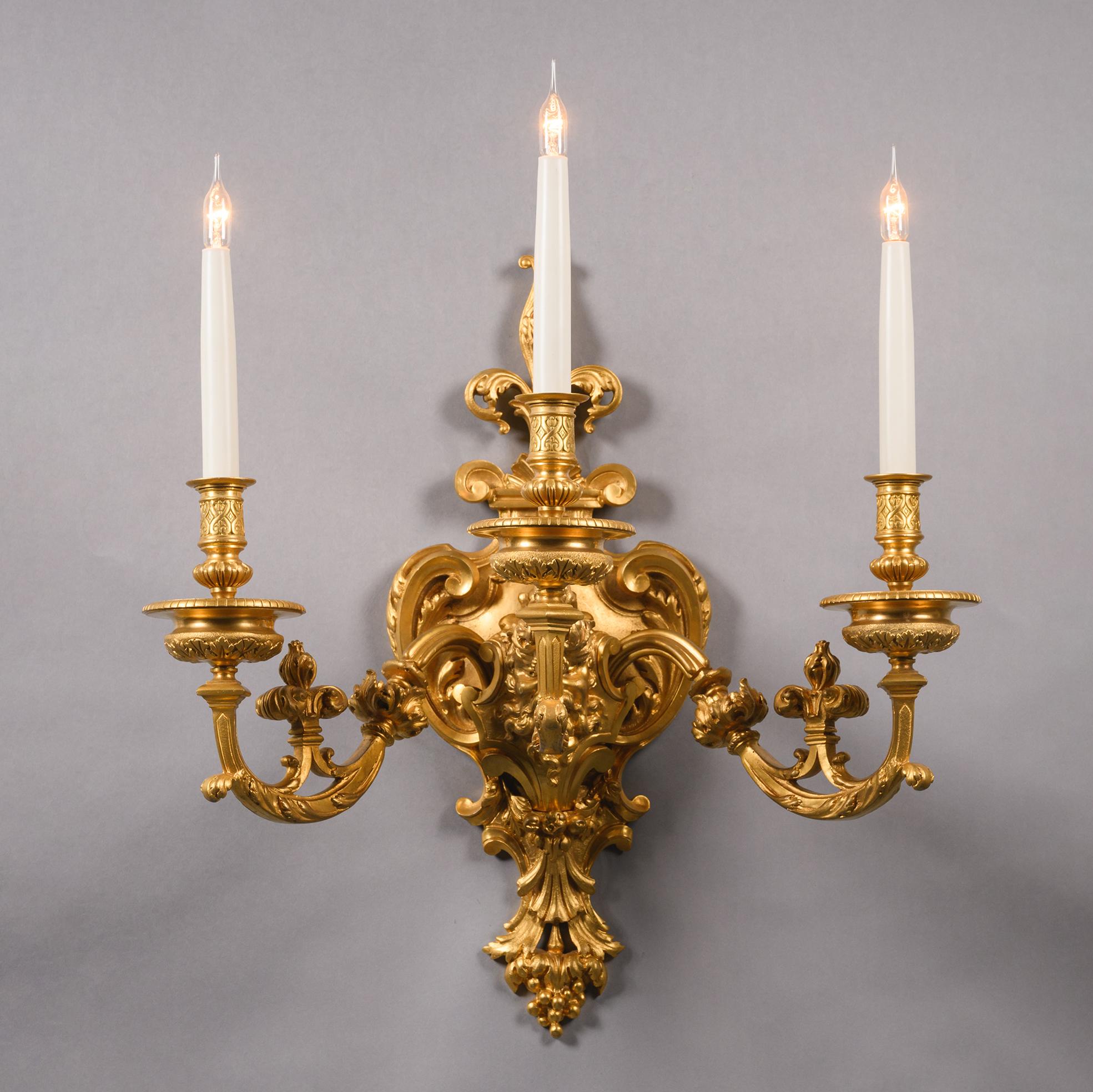 Doré Paire d'appliques murales à trois lumières en bronze doré en vente