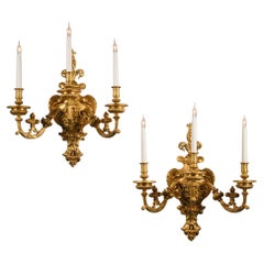 Coppia di applique da parete a tre luci in bronzo dorato