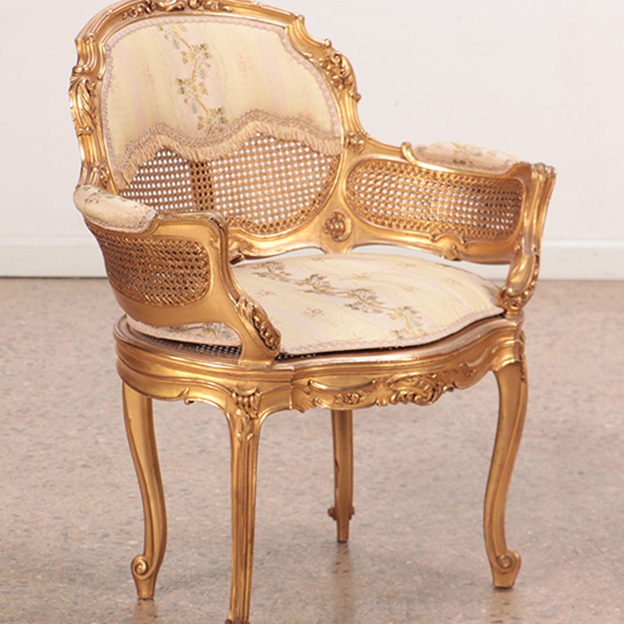A pair of giltwood and carved French Louis XV style bergere chairs in original gilt finish, circa 1900.
