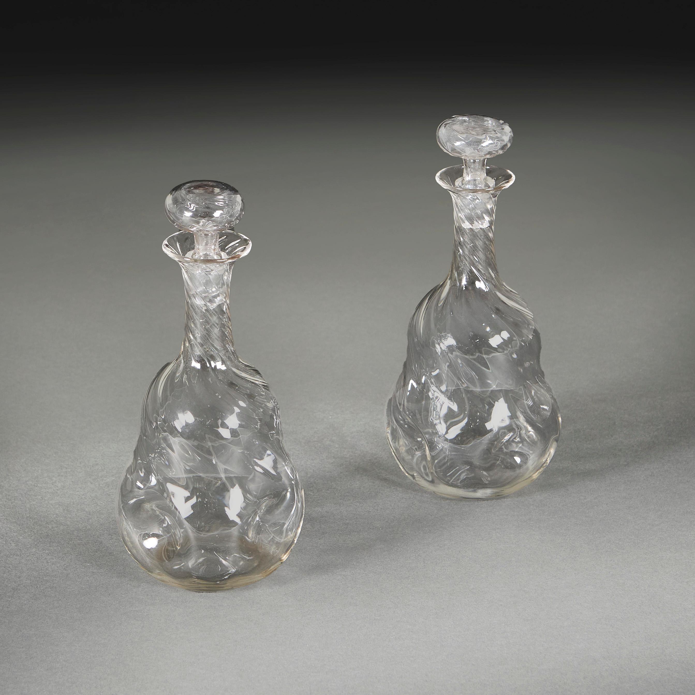 An unusual pair of Arts and Crafts decanters of double gourd dimpled and wrythen mallet form, with hollow bun stoppers.

England, circa 1890
Height 26.00cm
Width  10.00cm