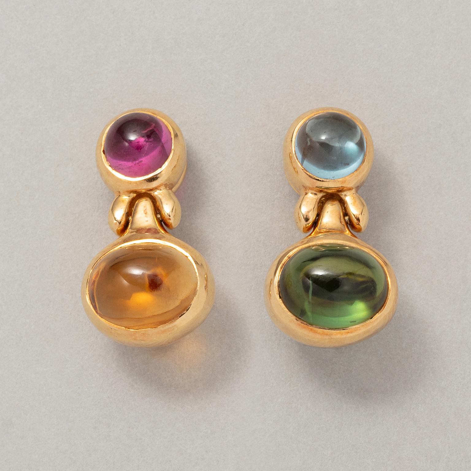 A pair of 18 carat yellow gold earrings set with different coloured gemstones. The left earring consists of a round cabochon cut aquamarine with an oval cabochon cut peridot underneath. The right earring has the same shape but is set with a pink