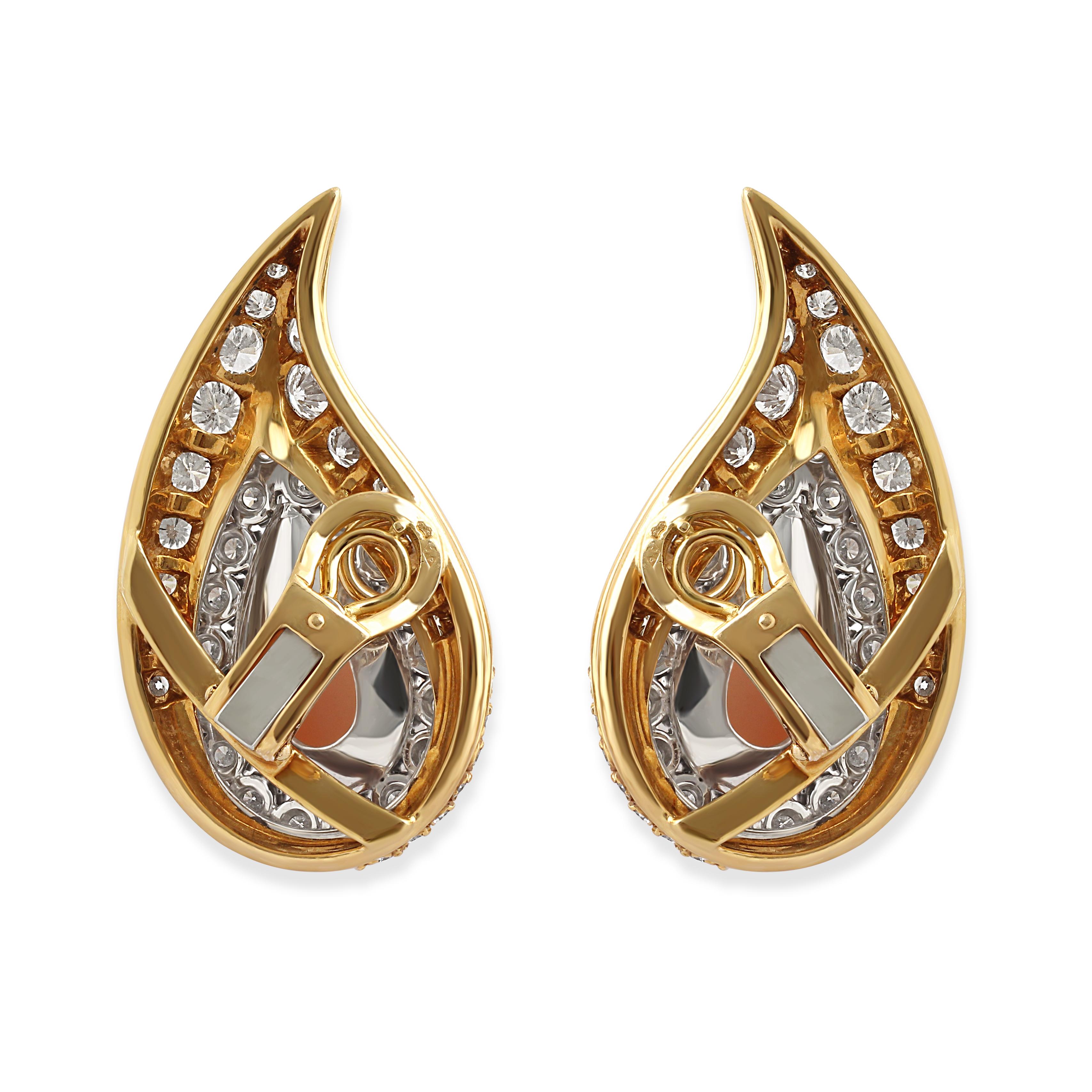 A pair of diamond and coral earrings in 18k gold. Set with pear-cut corals surrounded by round-cut diamonds crafted in an elegant tear drop design.