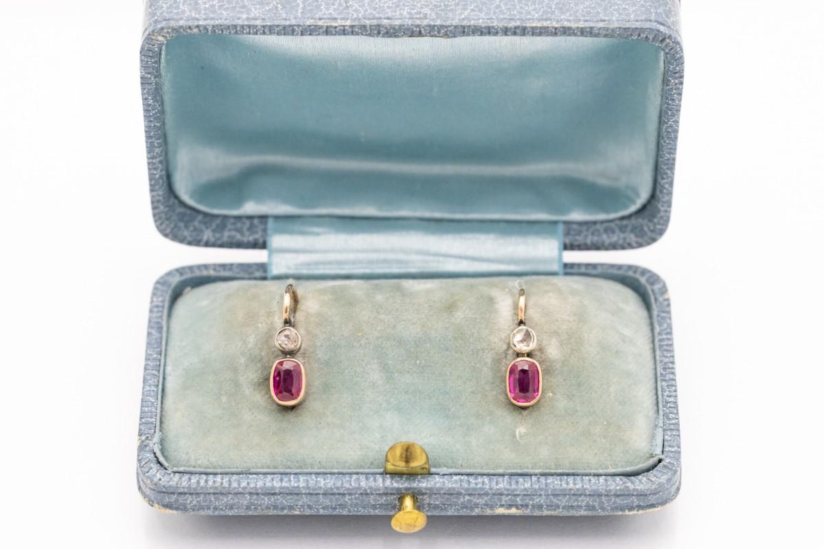 A pair of antique earrings made of 14-karat gold . Decorated with oval synthetic rubies and diamonds with a total weight of 0.16ct. Synthetic rubies were created at the end of the 19th century and became very popular in the early 20th