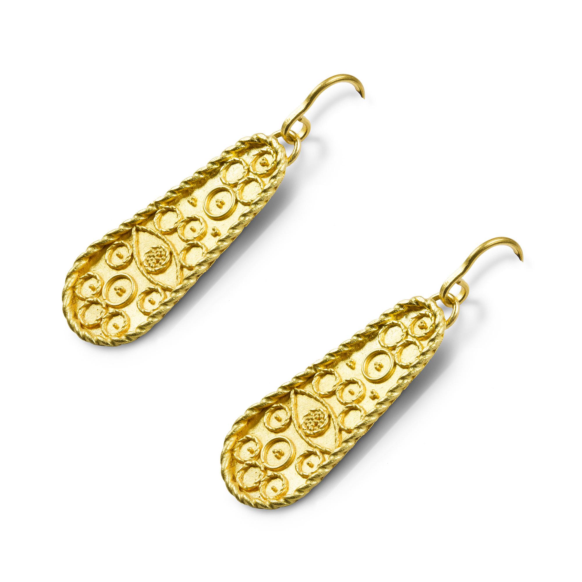 A pair of gold plaque earrings by Akelo, each elongated pear-shaped gold plaque, with twisted wire work border, decorated with an eye motif and circle design rendered using filigree and gold granulation, and embellished with granulation clusters, to