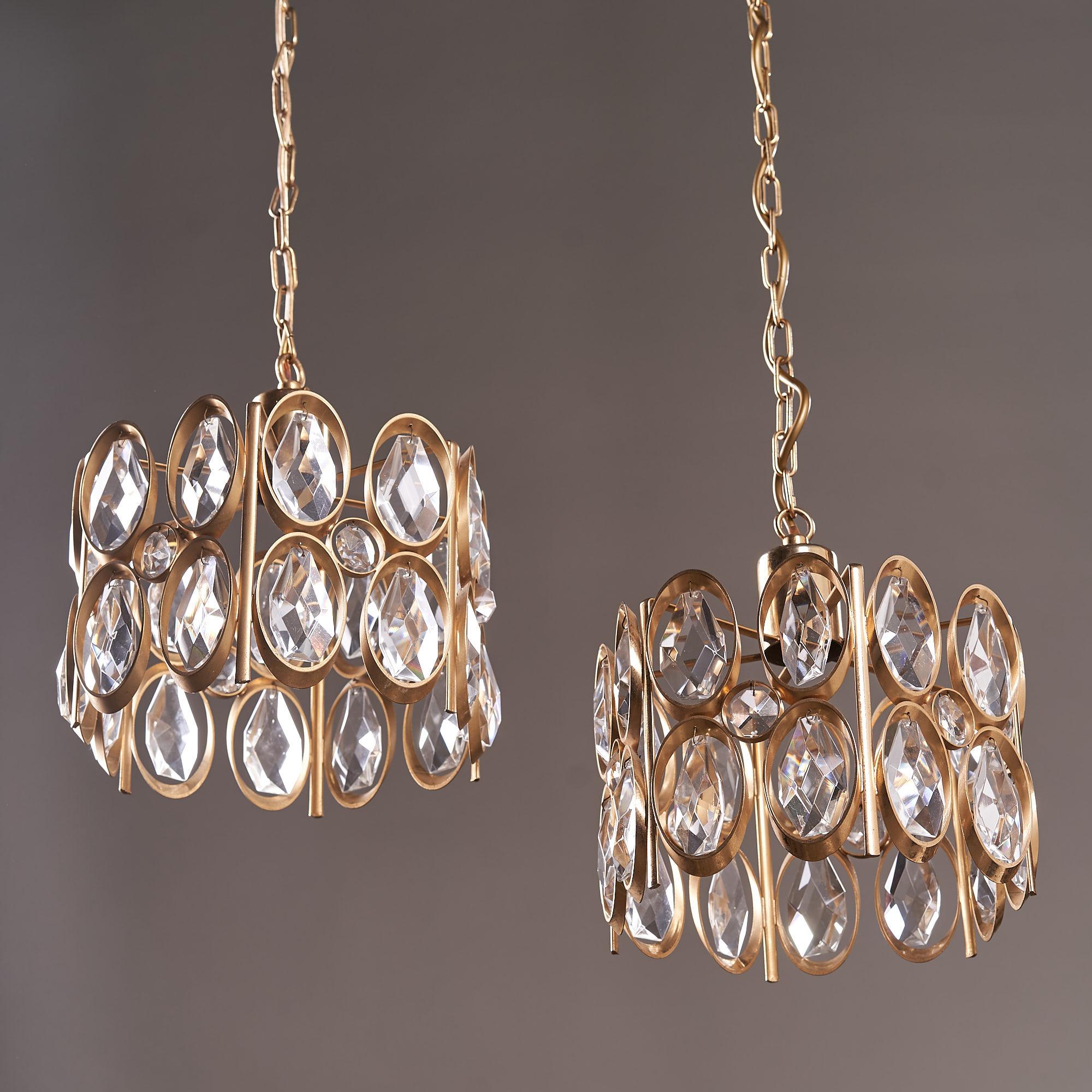 A pair of Hollywood Regency, gold-plated, brass framed, glass crystal chandeliers by German designer Palwa, circa 1960.    
  