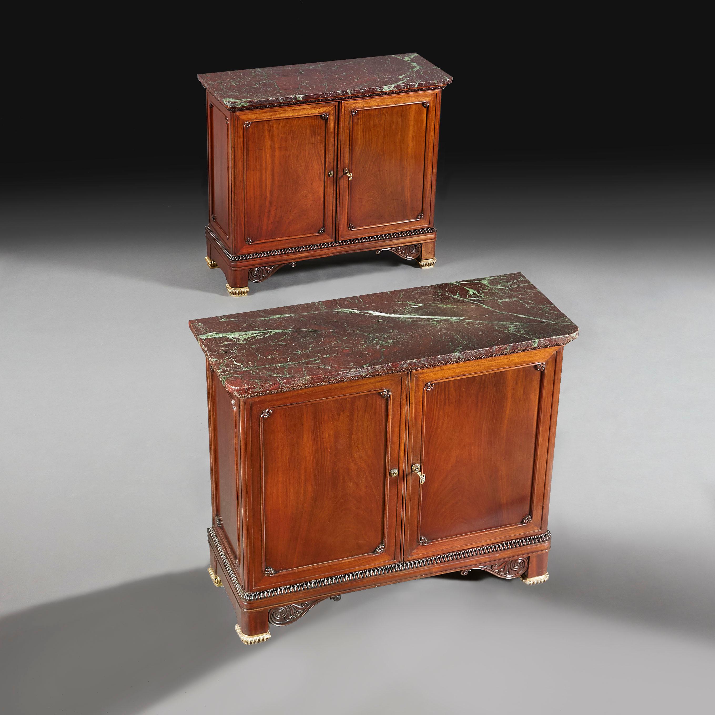 England, circa 1900

A fine pair of goncalo alves side cabinets with two panelled doors fitted with Bramah locks, shelves within, supported on square tapering feet with gilt bronze mounts and stylised anthemiums. The tops fitted with red Levanto